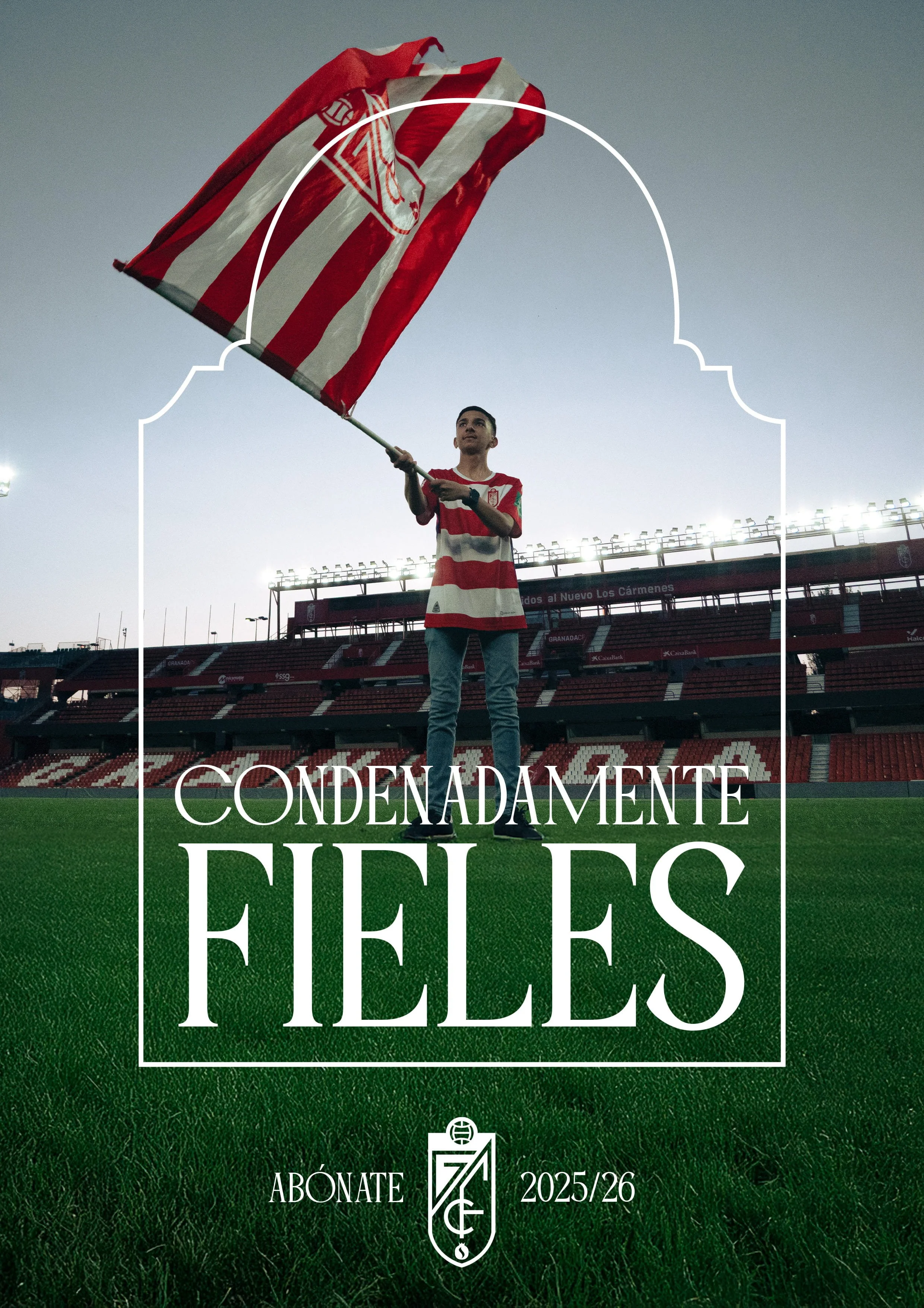 Un joven en un estadio sosteniendo una bandera de rayas rojas y blancas con un escudo en medio, sobre un campo de fútbol, durante el atardecer. Texto en la imagen que dice "Condénamente felices" y "Abónate 2025/26".