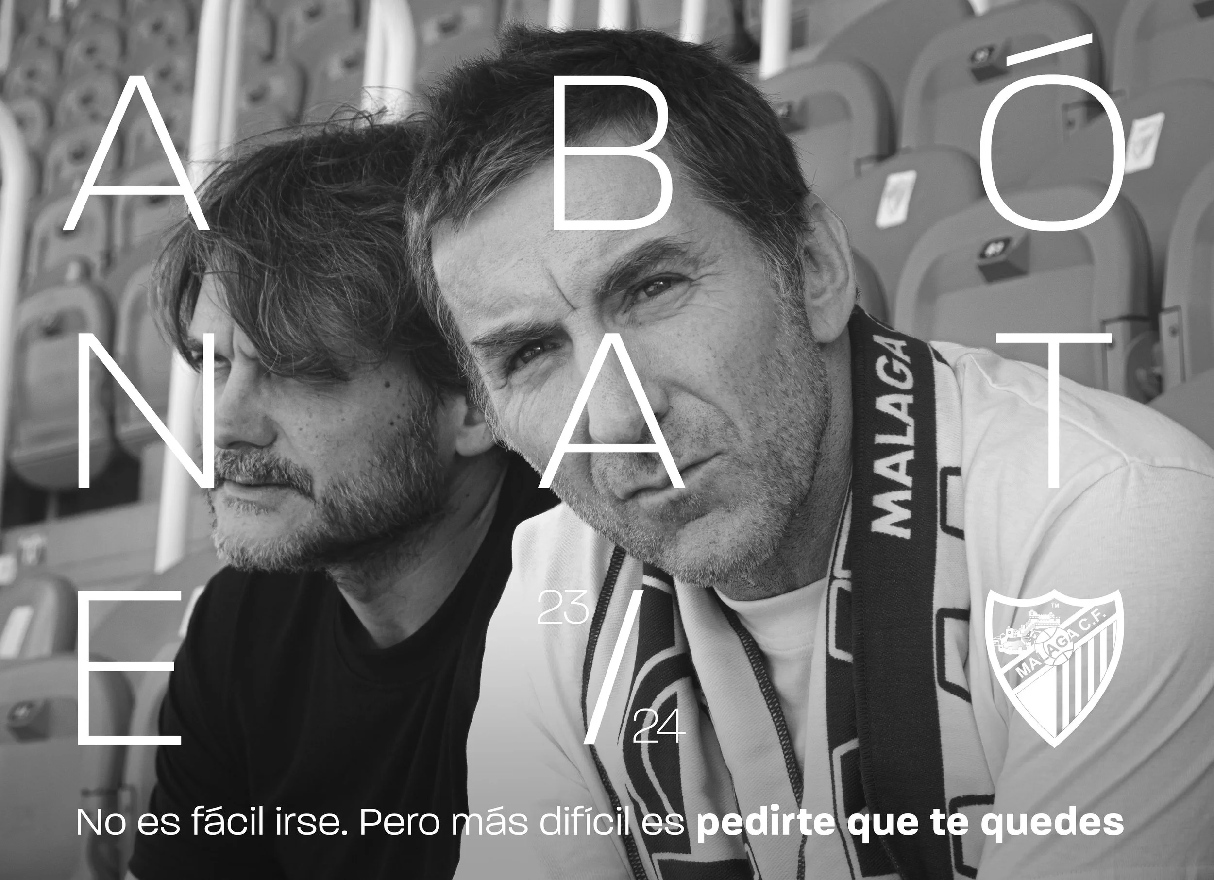 Dos hombres con expresión seria, uno con barba y otro calvo, en un estadio vacío con asientos de fondo, llevan chaquetas con logotipos deportivos y están muy juntos mirando hacia la cámara. Texto en la imagen dice: 'NO ES FÁCIL, PERO MÁS DIFÍCIL ES P