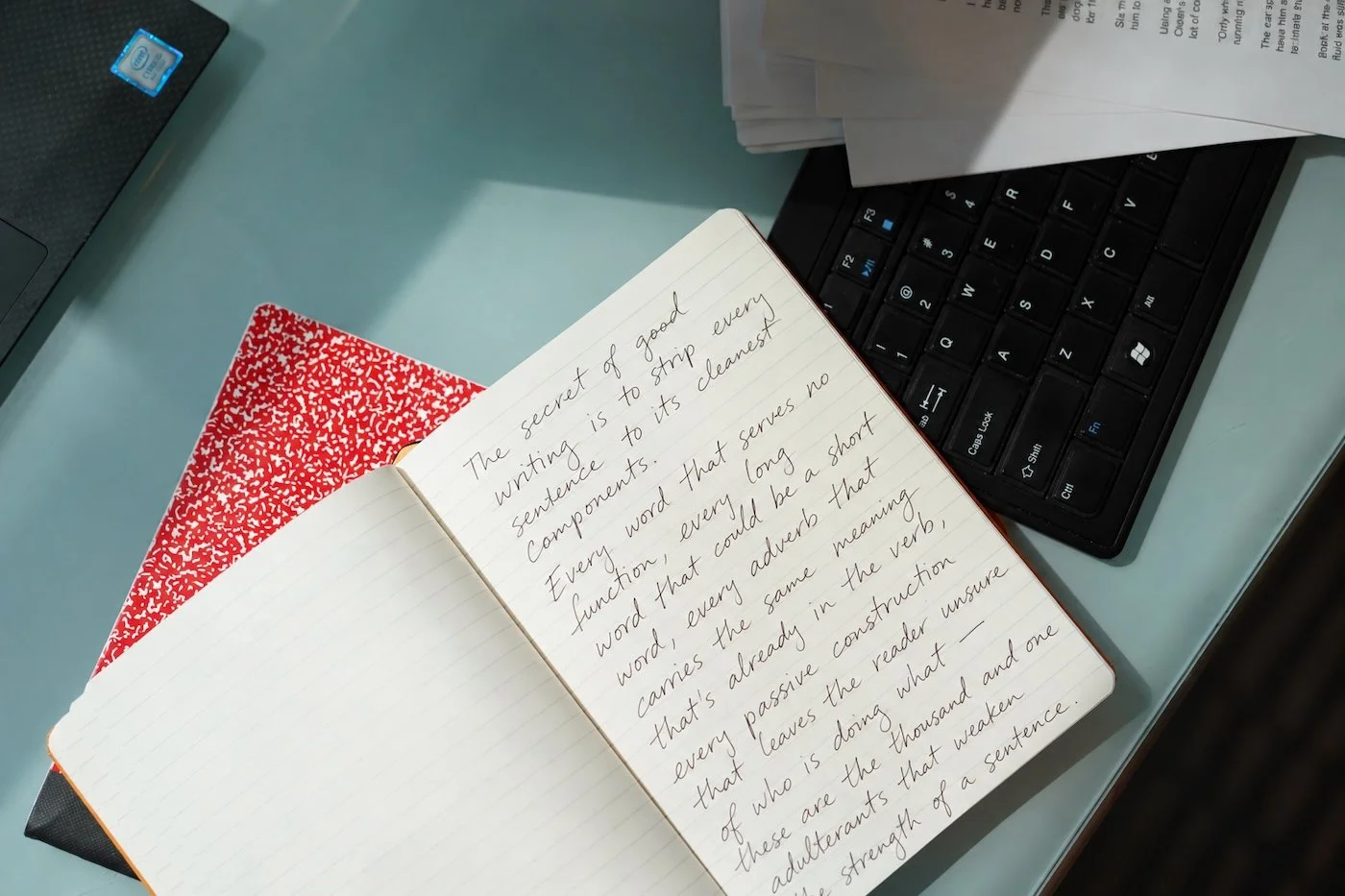 Notebook open with keyboard on a teal desk
