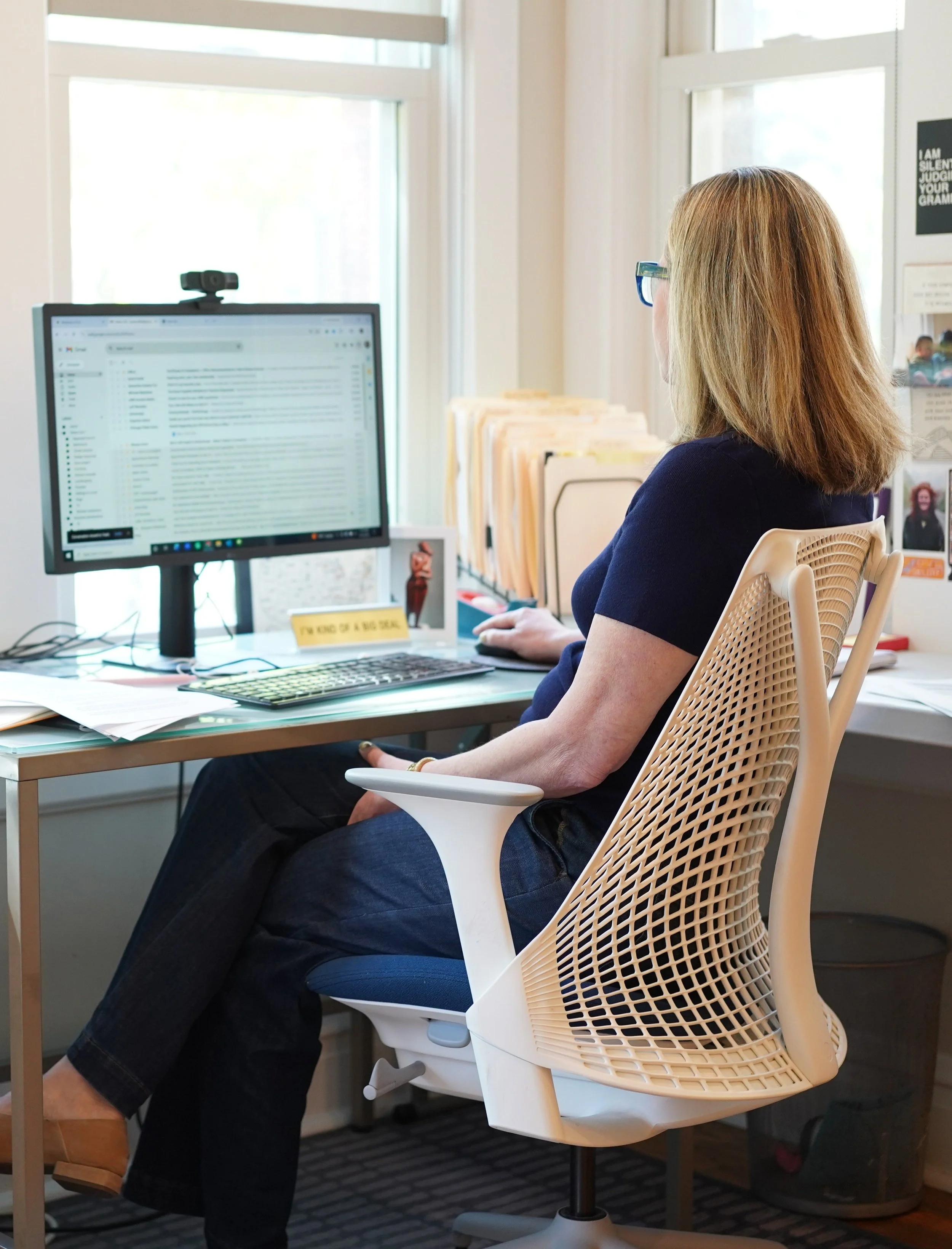 Laurie sitting at office desk in bright filled room