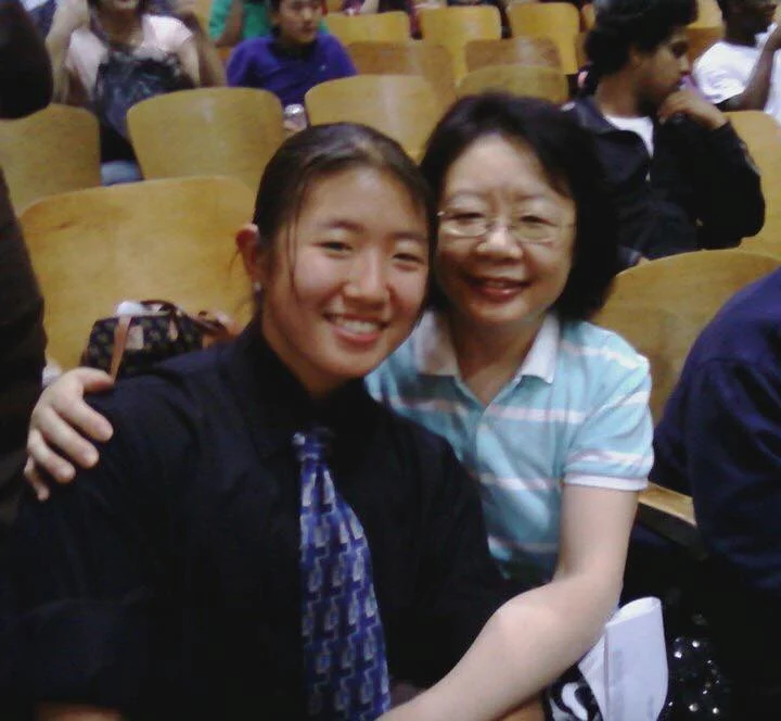 Jiggy Yoon and her mother smiling together in an auditorium