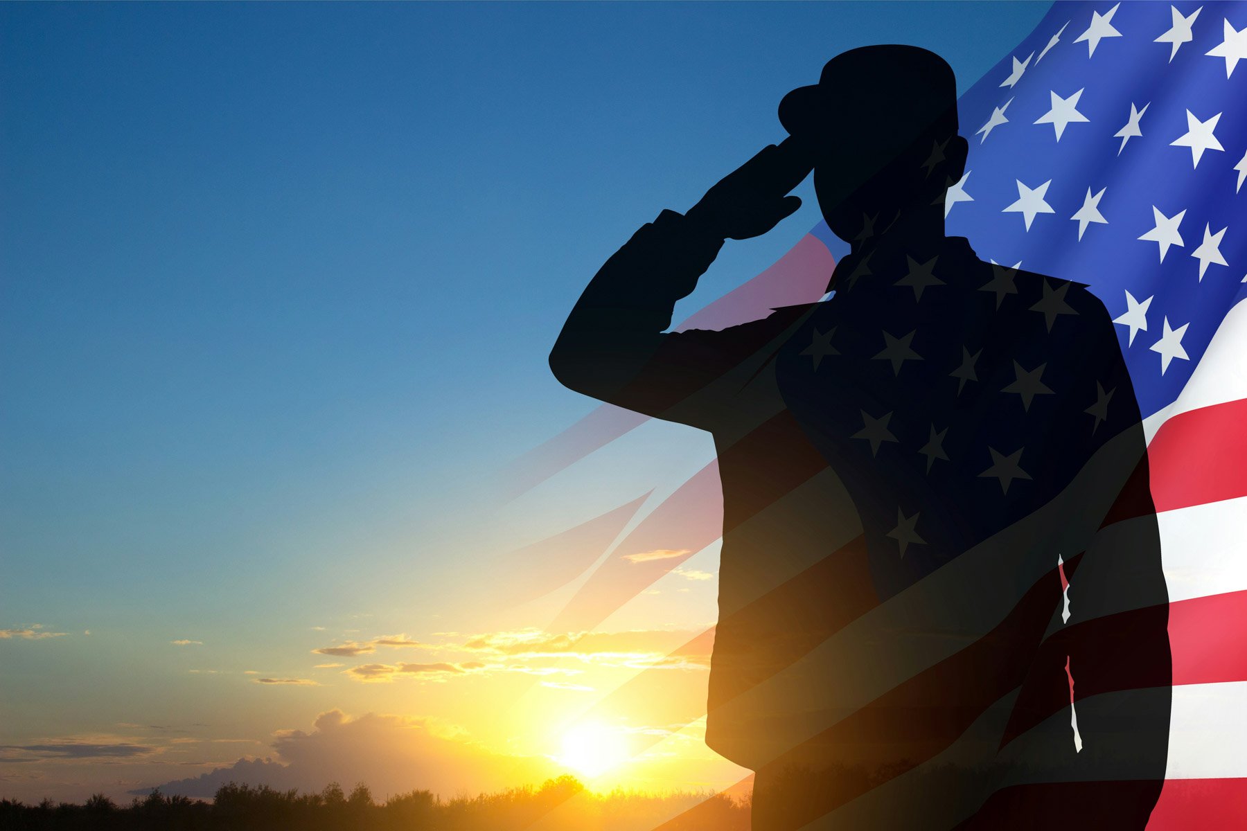Silhouette of a person saluting with an American flag overlayed on the right side, against a sunset sky with clouds.
