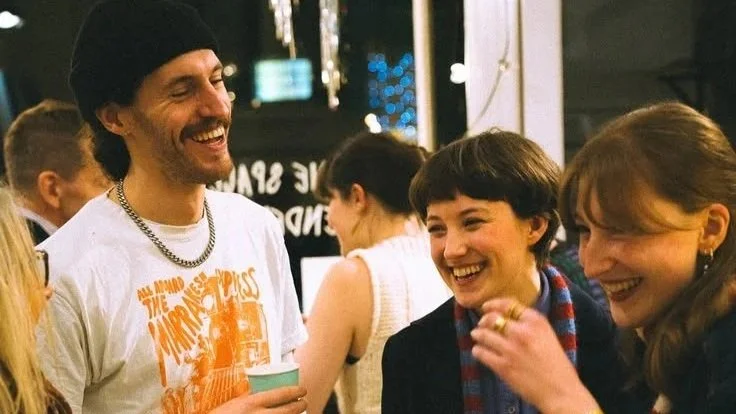 Group of people talking and laughing at a social gathering or party.