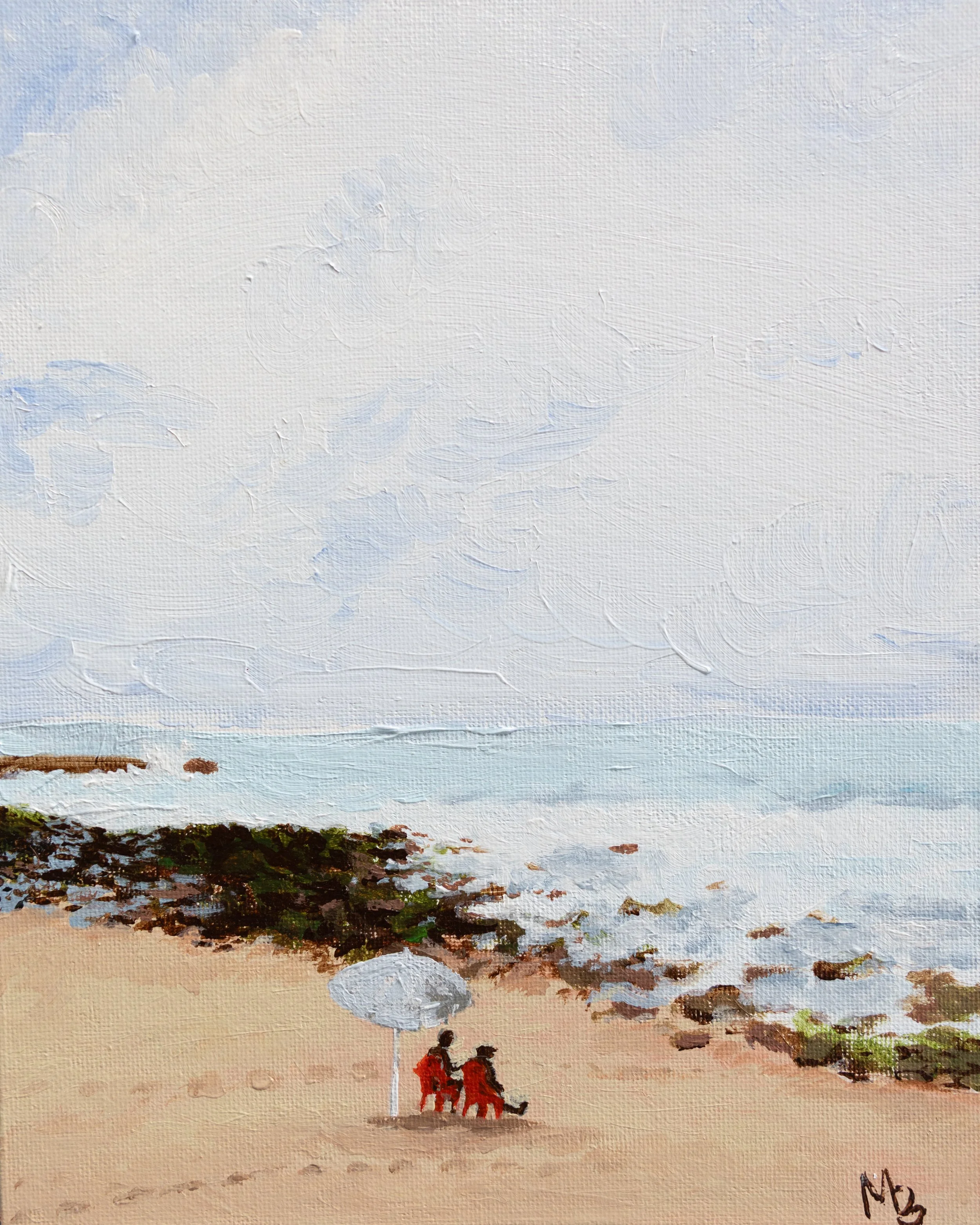 A beach scene with two people sitting on the sand, walking along the shoreline, and a city skyline in the distance under a cloudy sky.