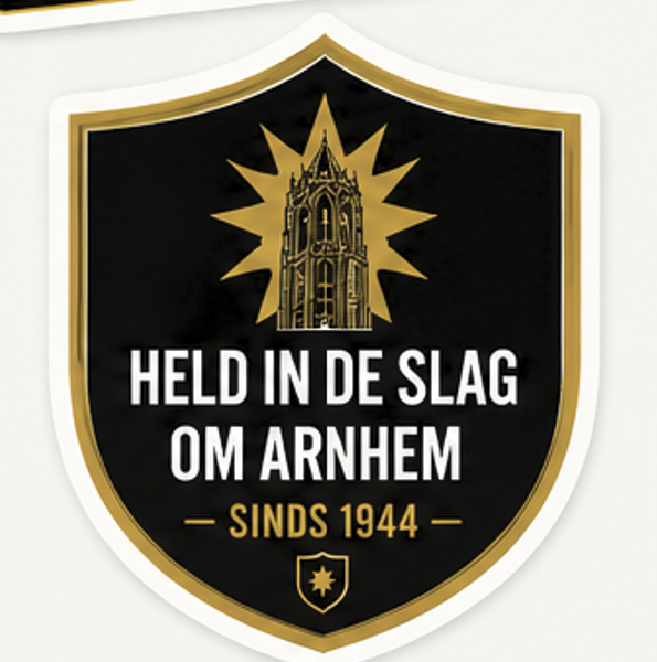 Een badge of embleem met een zwarte achtergrond, gouden rand en een afbeelding van een toren met een stervormige straling eromheen. Text op de badge: 'Held in de Slag om Arnhem' en 'Sinds 1944'.