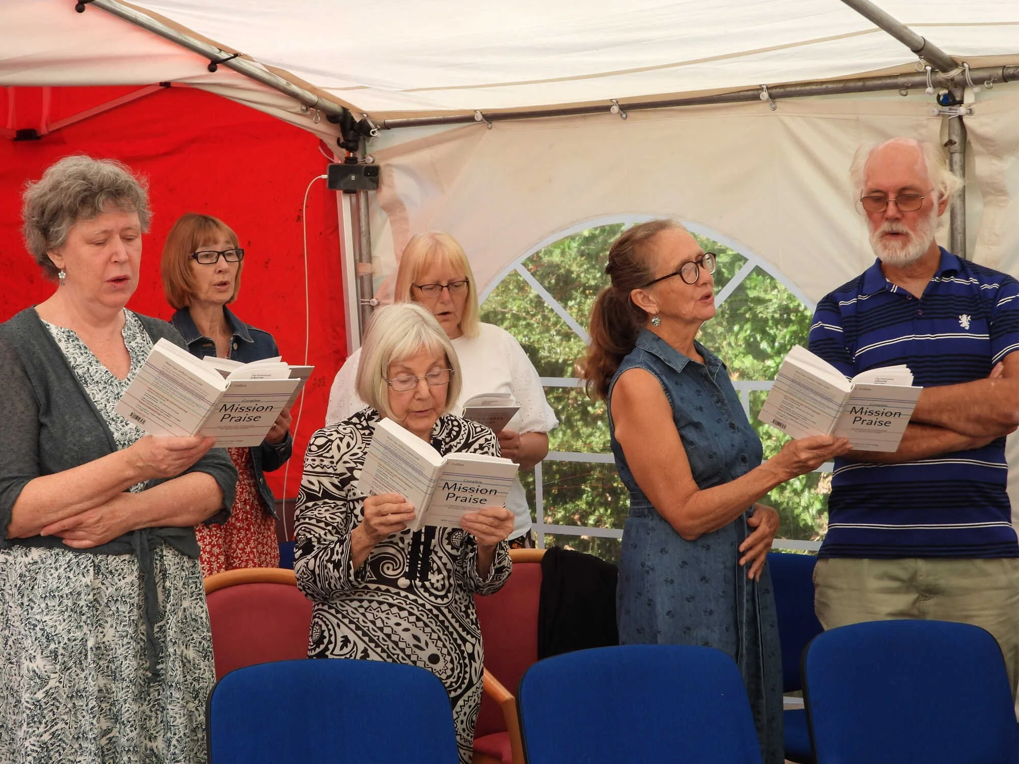 Members of Emmanuel Fellowship singing together at an outdoor gathering