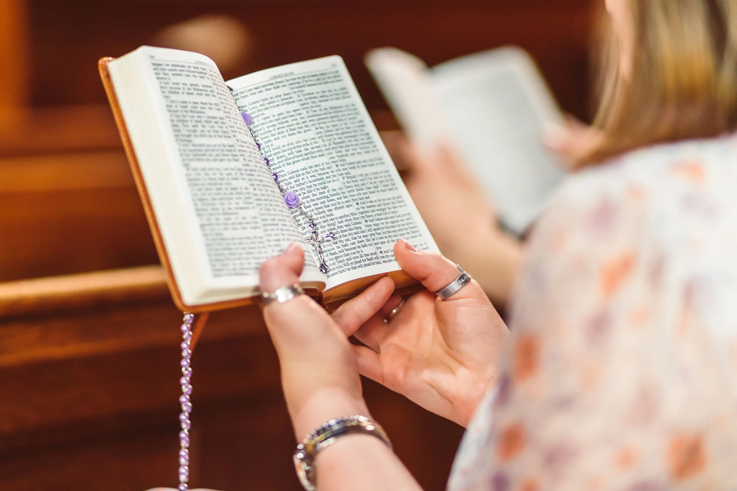 Person holding an open Bible during a church gathering.