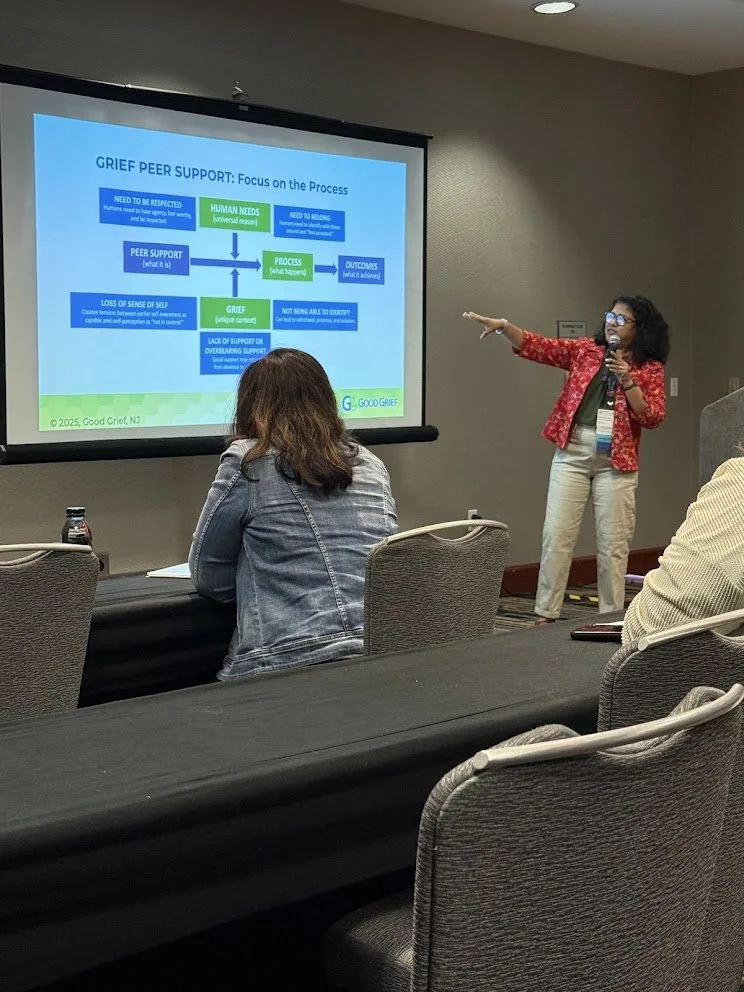 Mrittika Sen presenting research on grief peer support to an audience seated in a conference room.