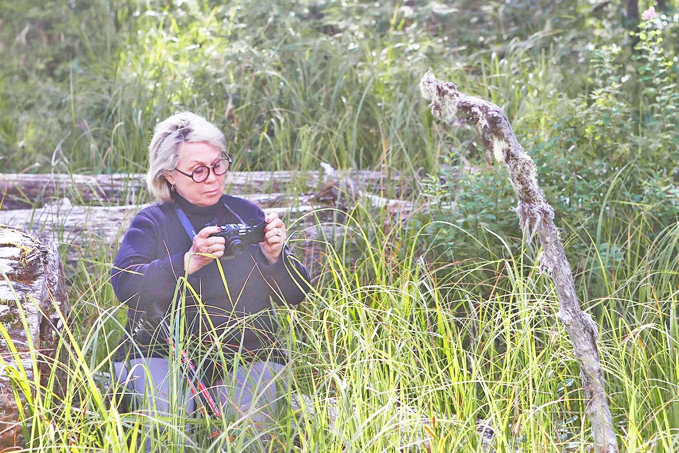 Carole in Grasses with camera, Great Bear Rainforest, BC,Unknown photographer