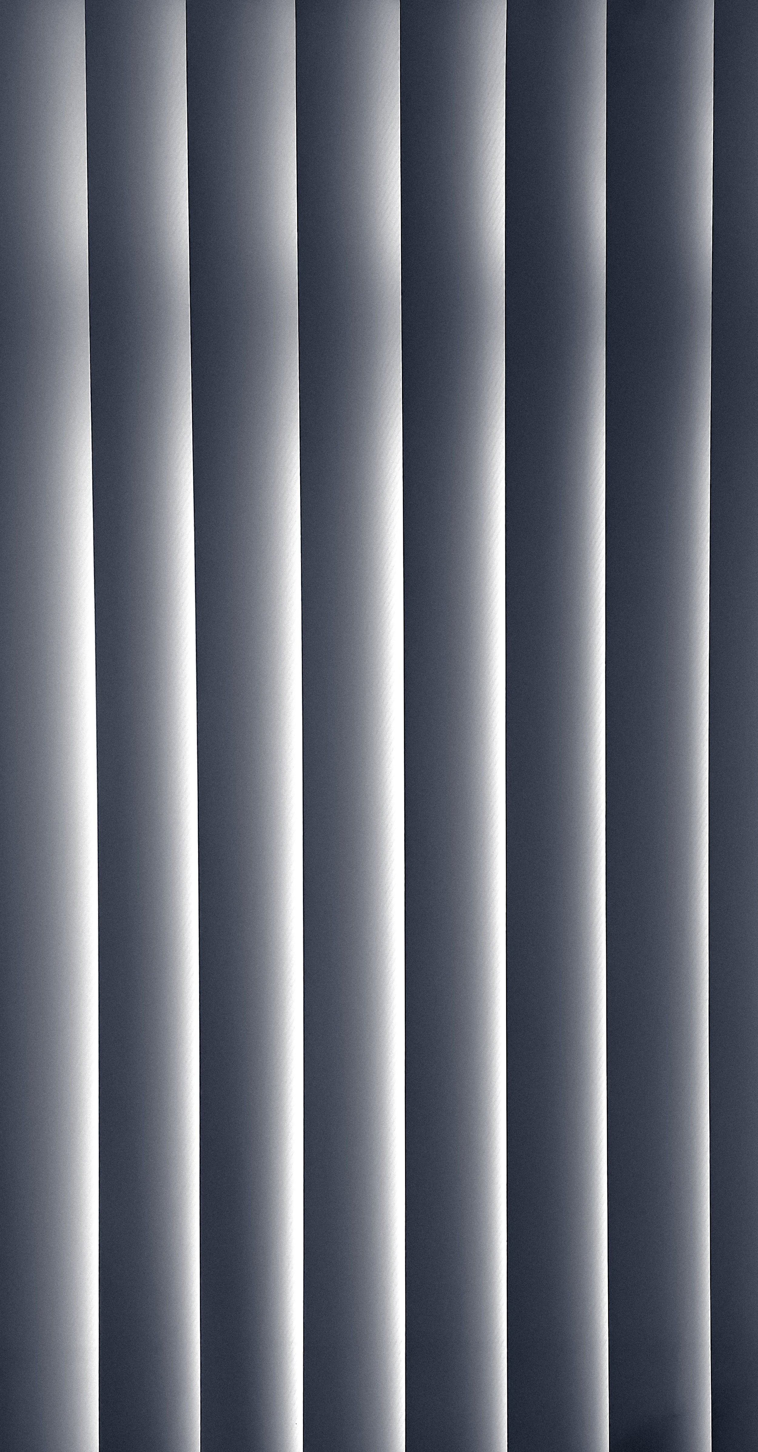 A close-up view of horizontal window blinds with alternating light and shadow.