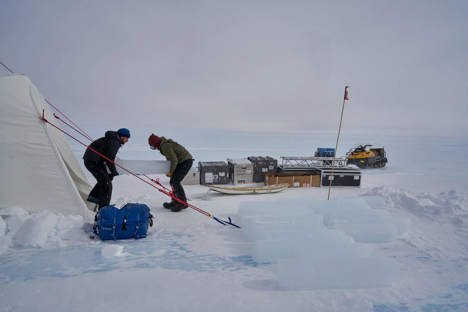 Scientists Austin Carter (left) and Sarah Shackleton transfer ice core from tent.