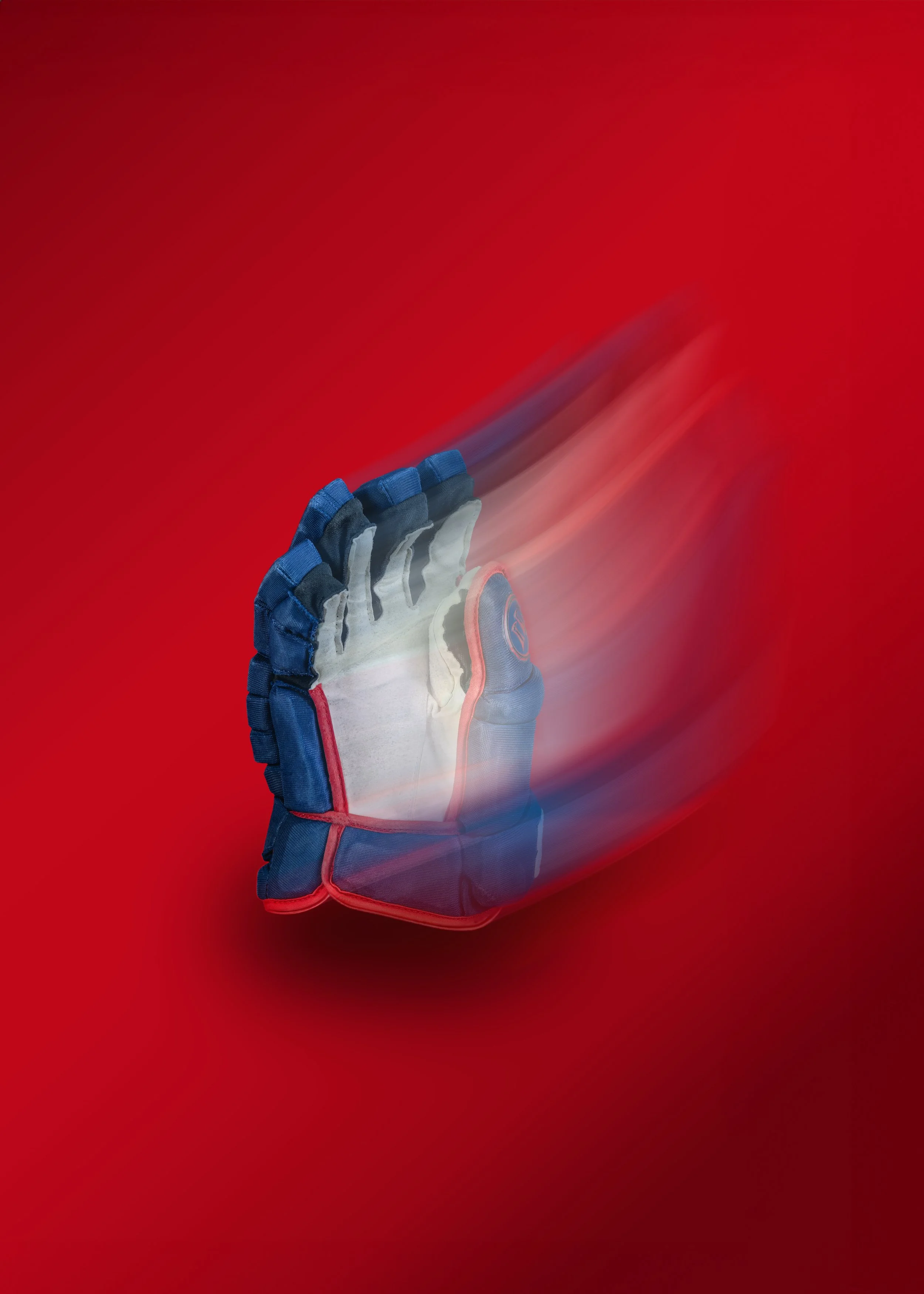 A hockey glove in motion, situated against a red background.