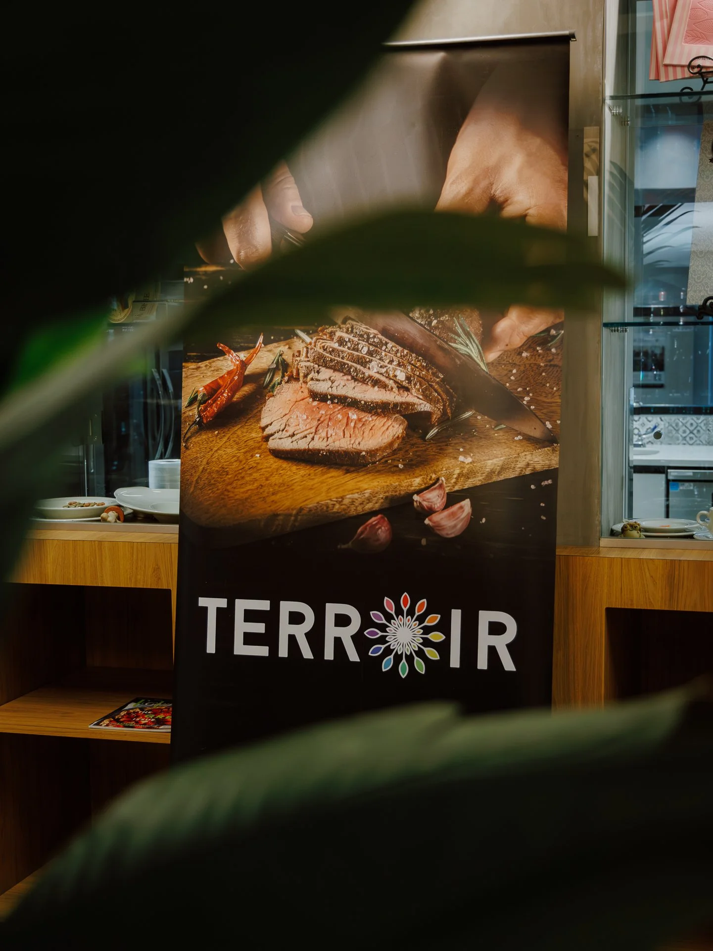 A promotional poster featuring sliced beef, garlic cloves, and chili peppers on a wooden board, with the word 'TERRITOR' visible at the bottom.