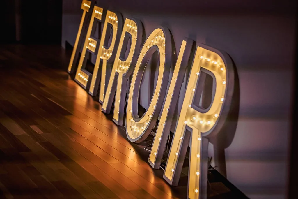 Large illuminated marquee sign spelling 'RENEW' with letter lights, placed on a wooden floor.