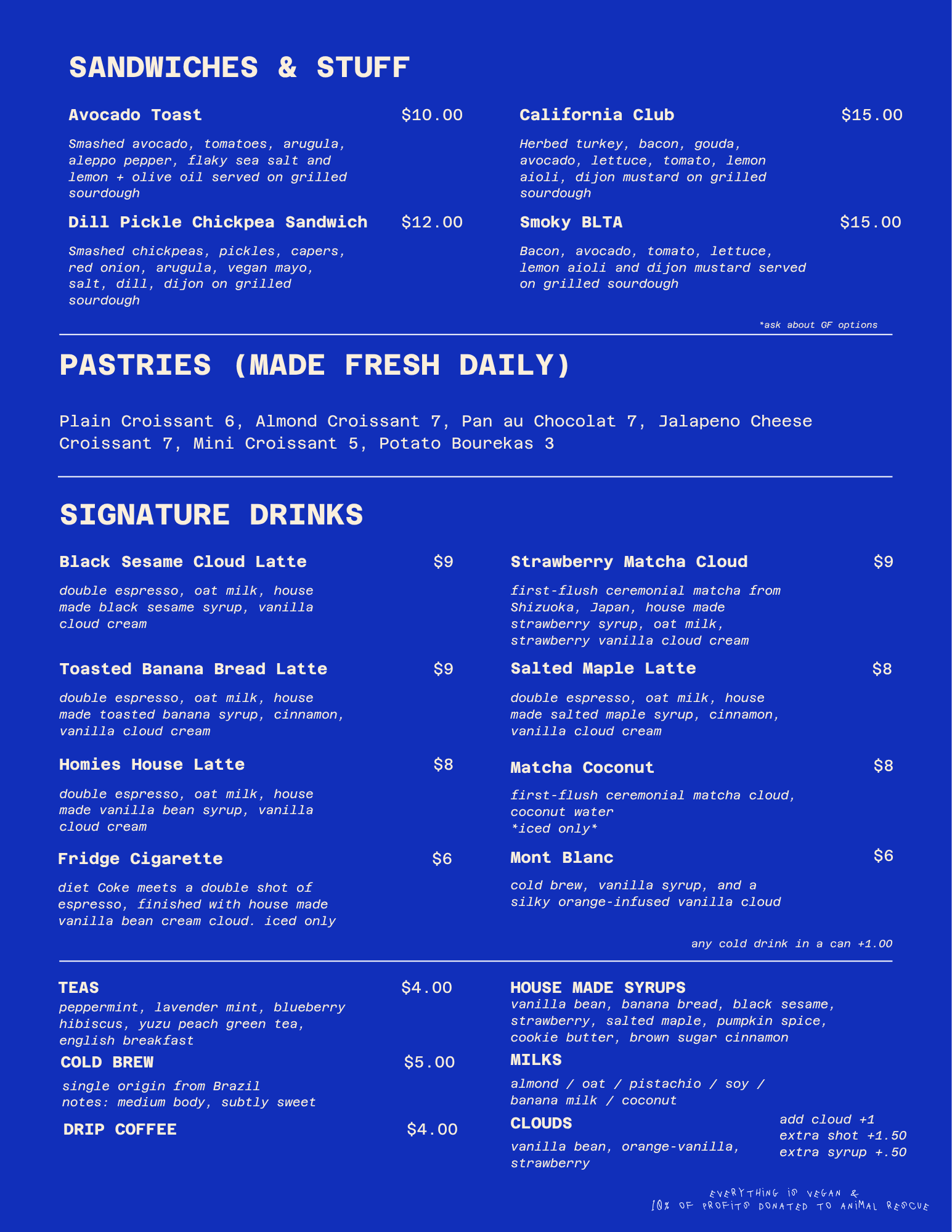 Blue menu featuring various food and drink options including sandwiches, pastries, signature drinks, teas, cold brew, house made syrups, milks, and additional notes about vegan options and animal rescue donations.