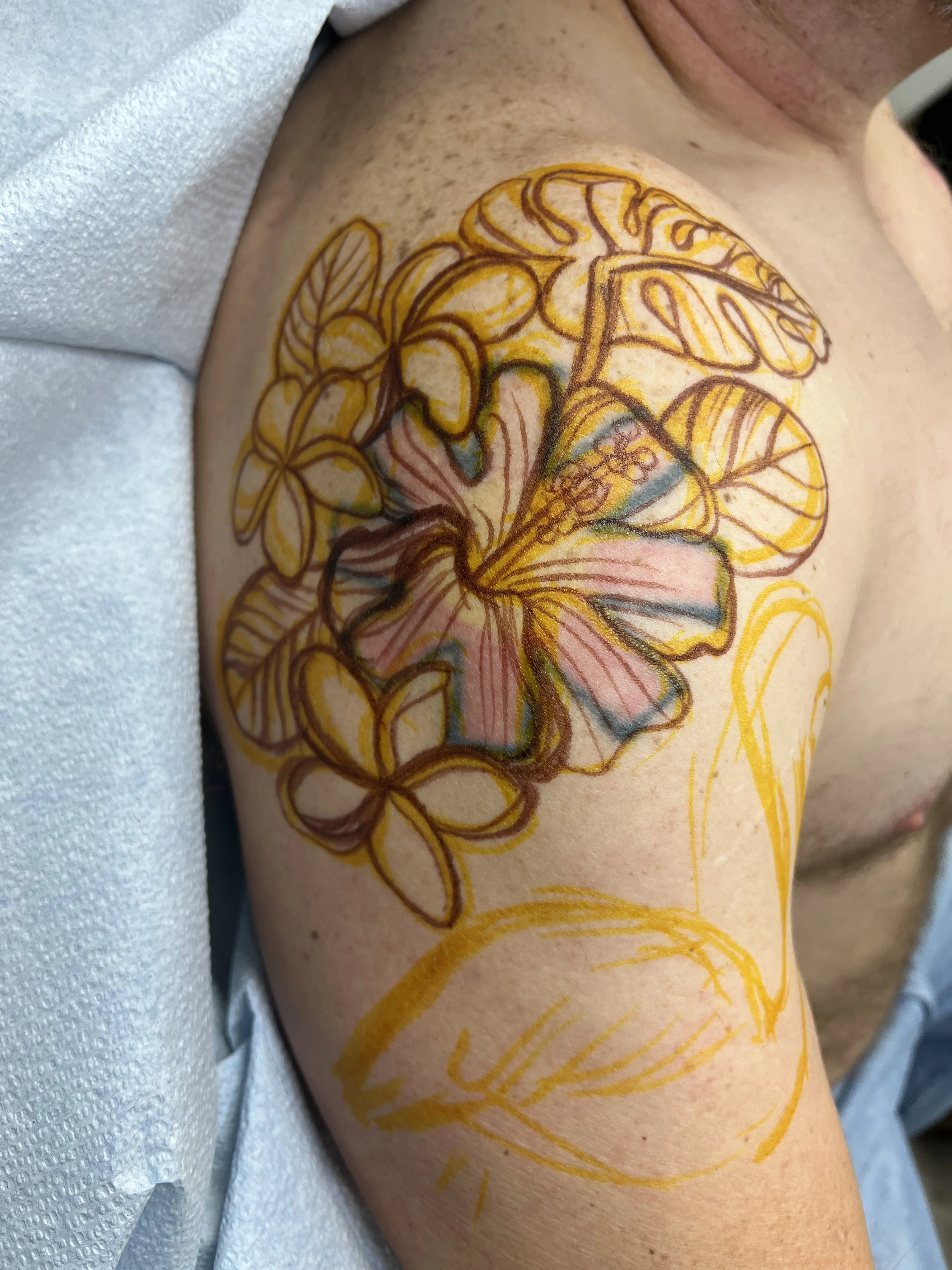 the original tattoo with sharpie depicting where the hibiscus and flamingo in the new tattoo will go