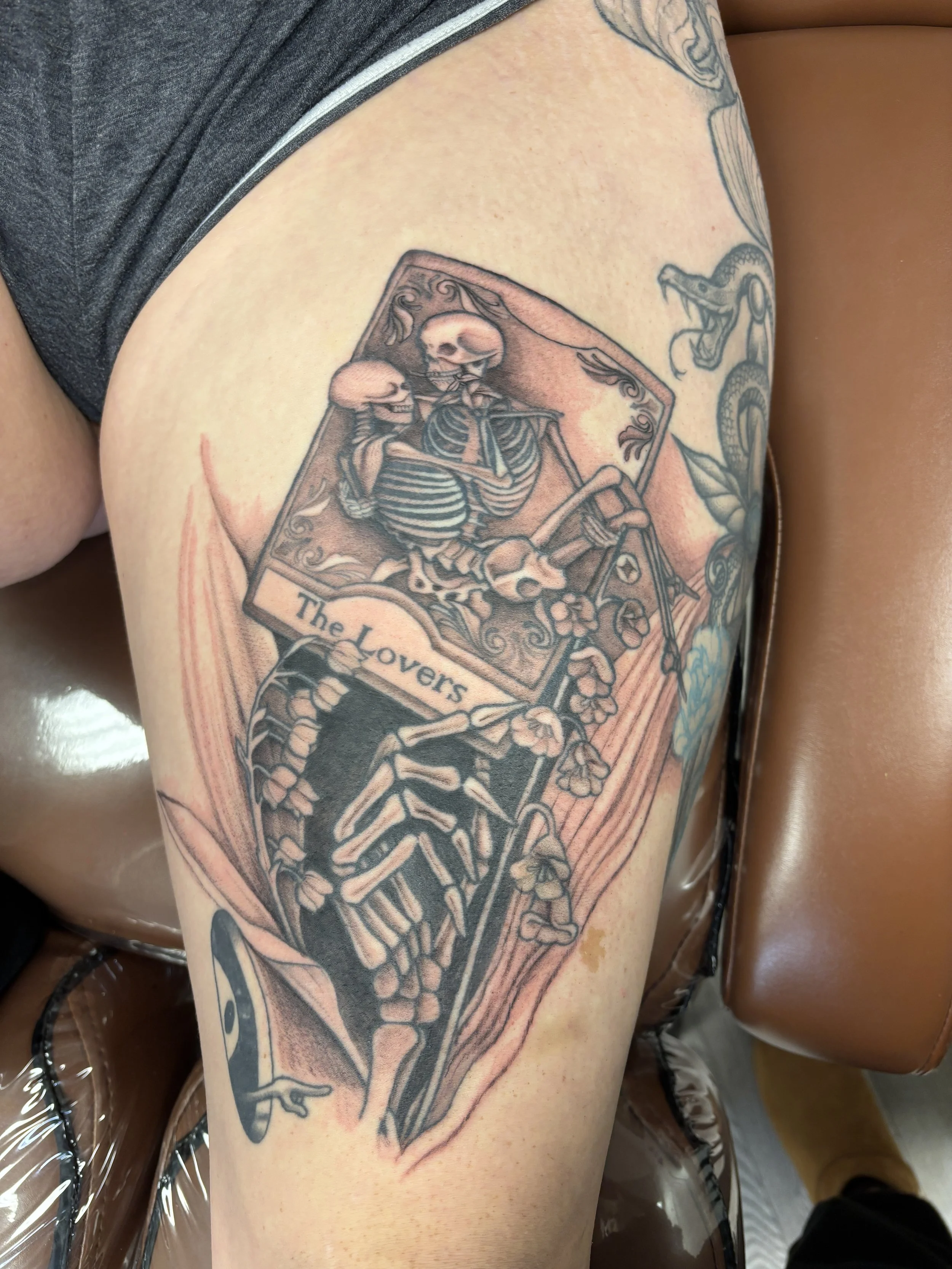 Tattoo of the lovers tarot card with skeletons. also held by a skeleton hand