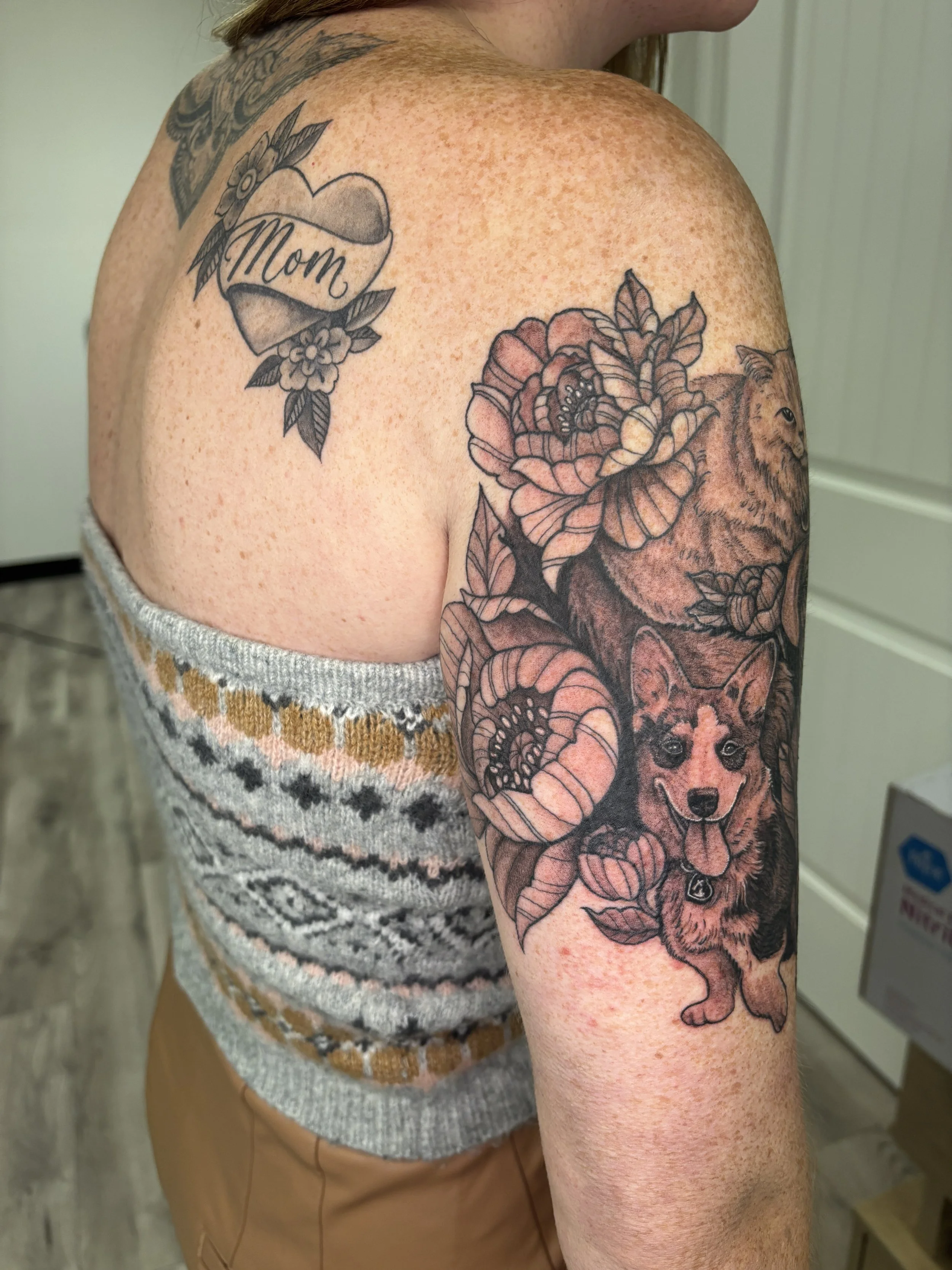 Fresh tattoo of a corgi, a cat, and a retriever