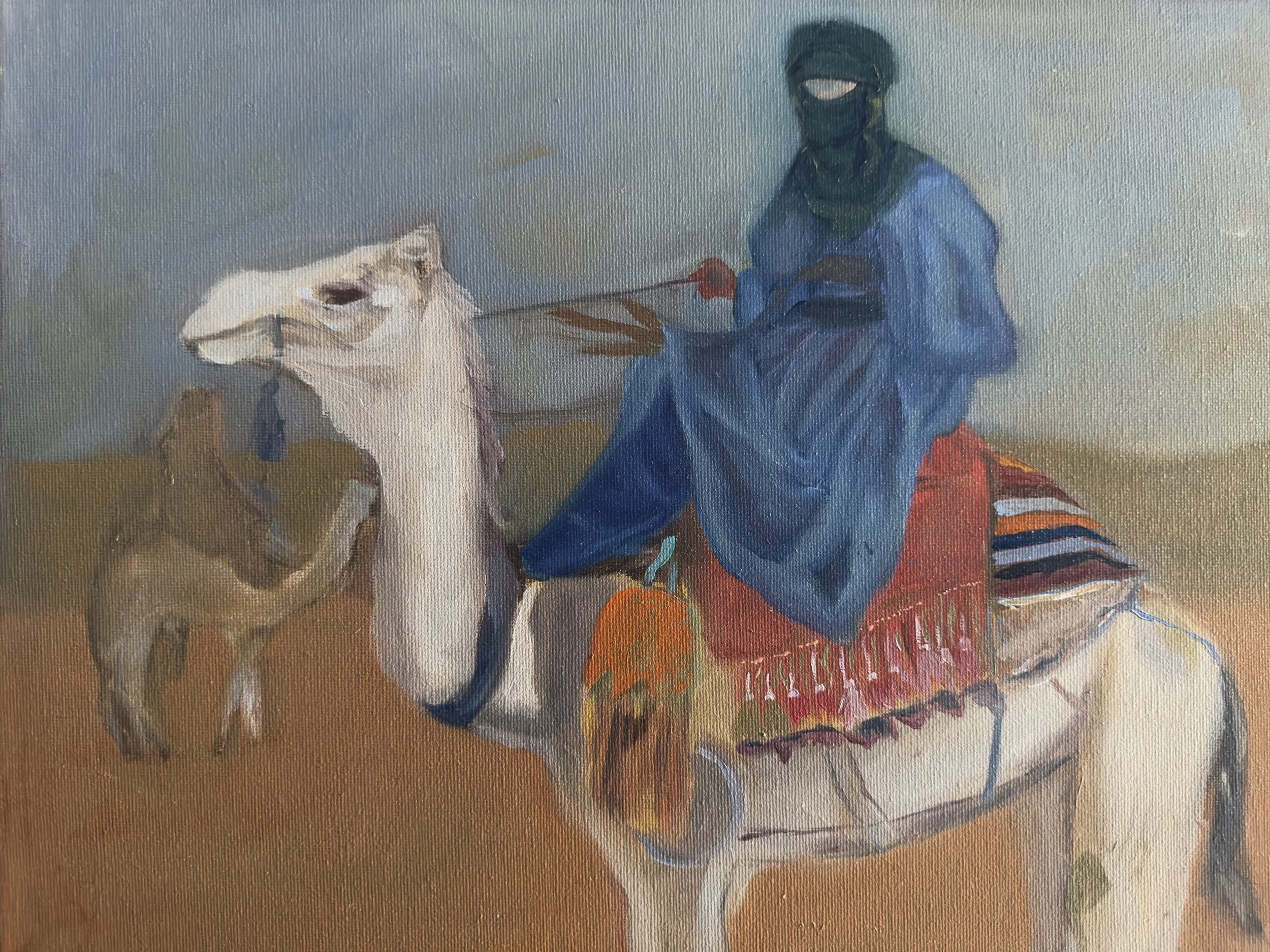A person dressed in blue protective gear and face mask holding a leash attached to a dog, sitting on a colorful striped blanket.