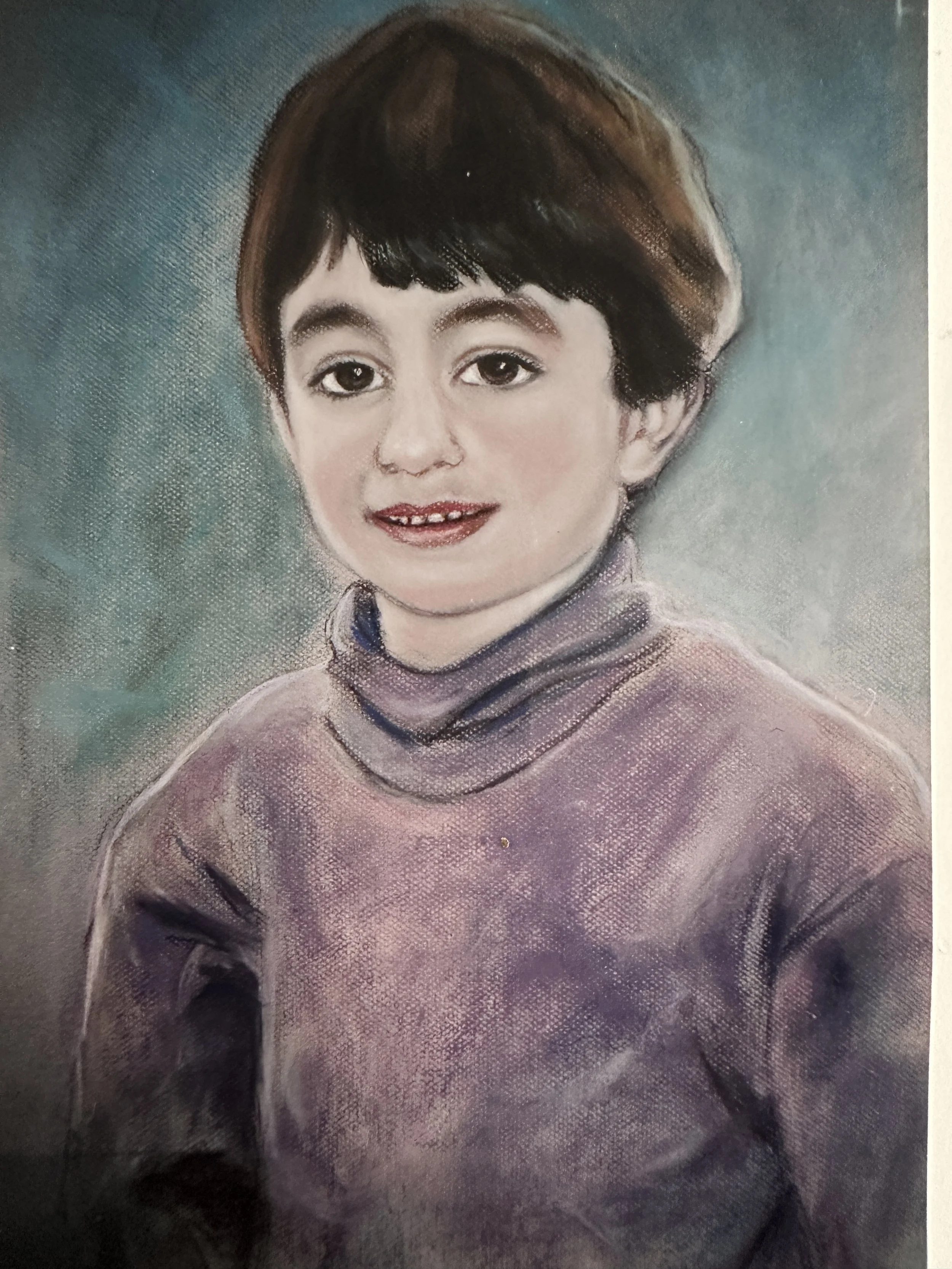 A detailed pencil or pastel portrait of a young child with short dark hair, expressive eyes, a slight smile showing small teeth, wearing a high-collared sweater, against a blue-green textured background.
