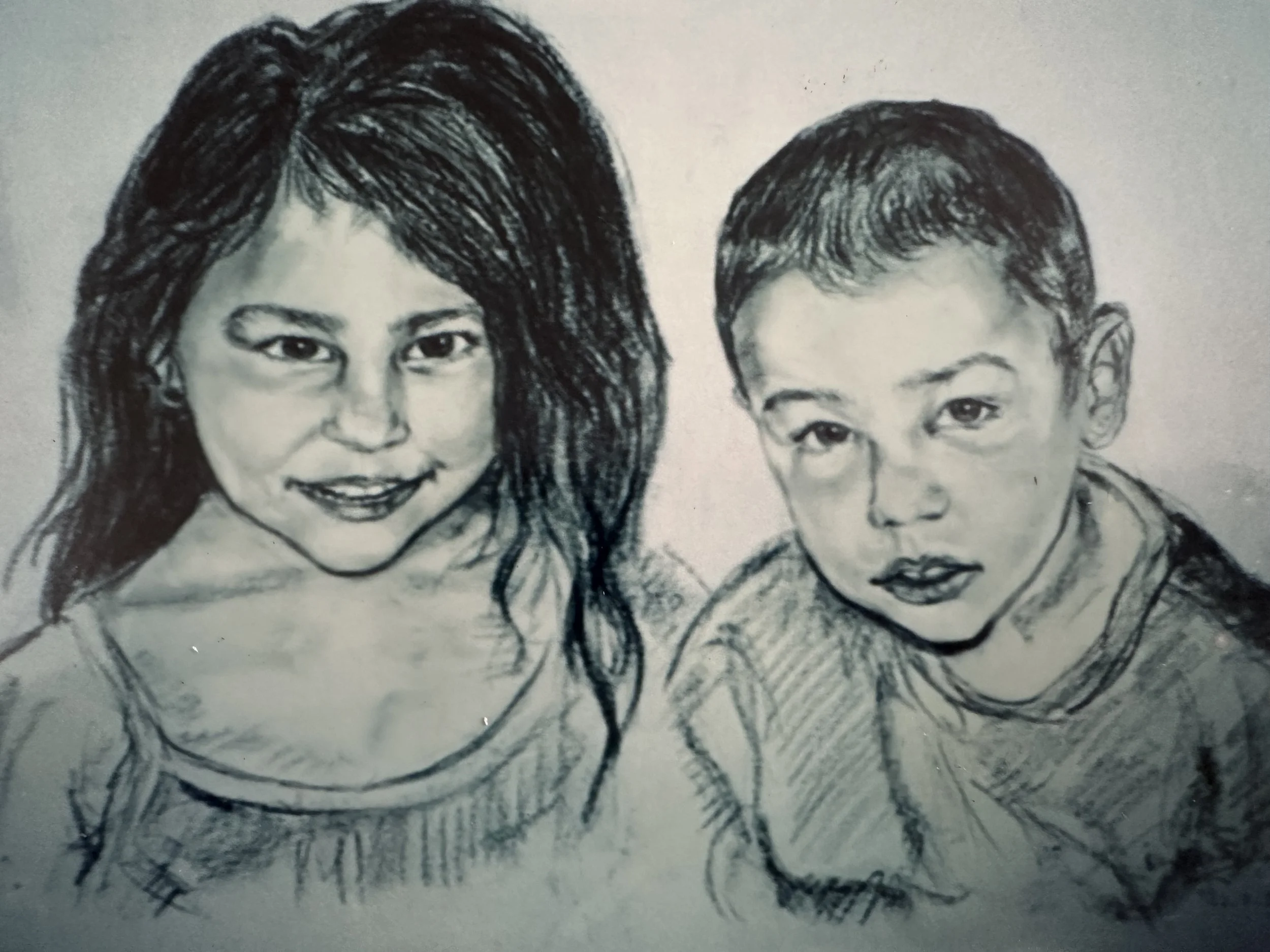 A black and white sketch of a woman with long, wavy hair and a young boy with short hair, both facing forward.