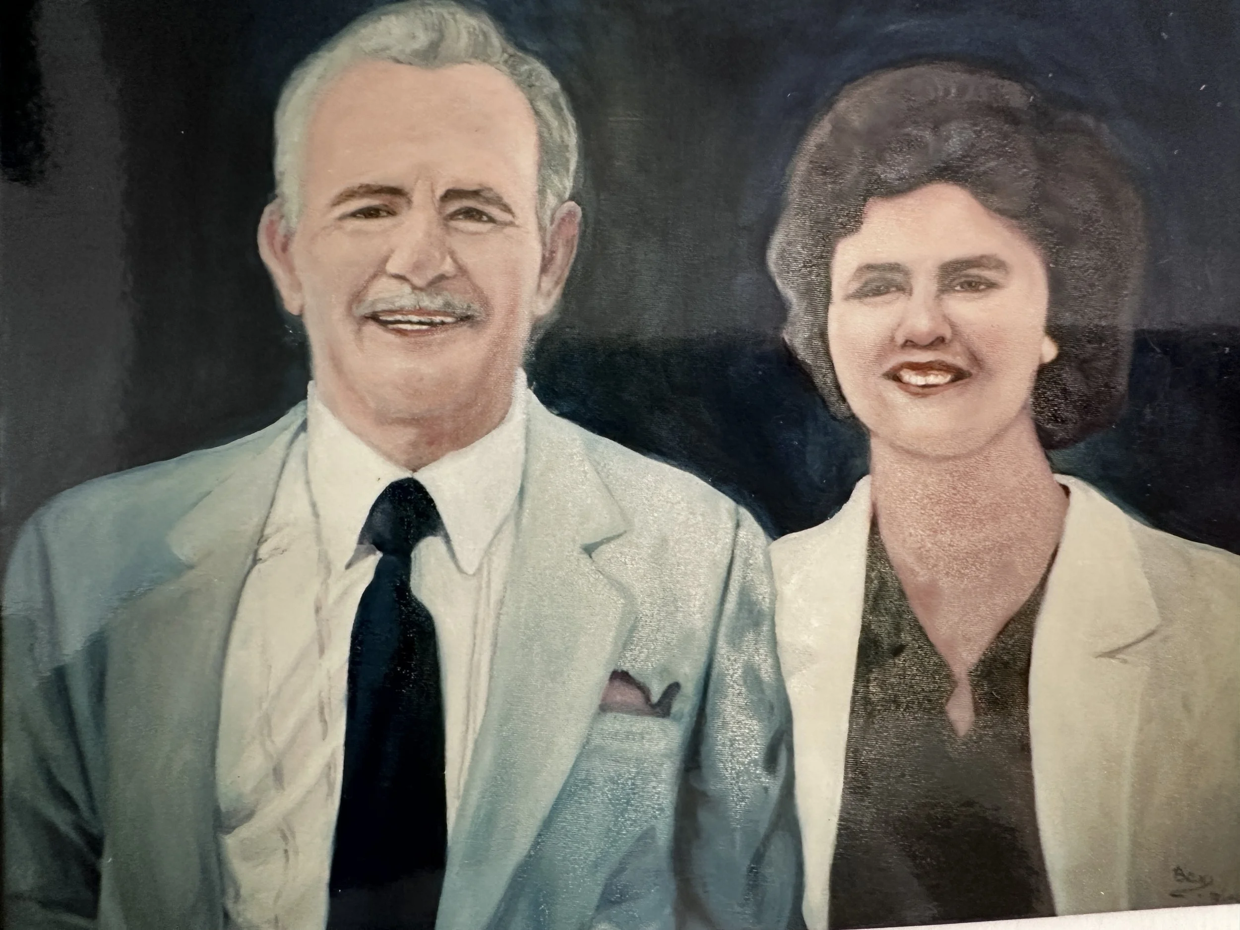 Painting of a smiling man in a white suit with a black tie and a woman with dark hair in a white dress, against a dark background.