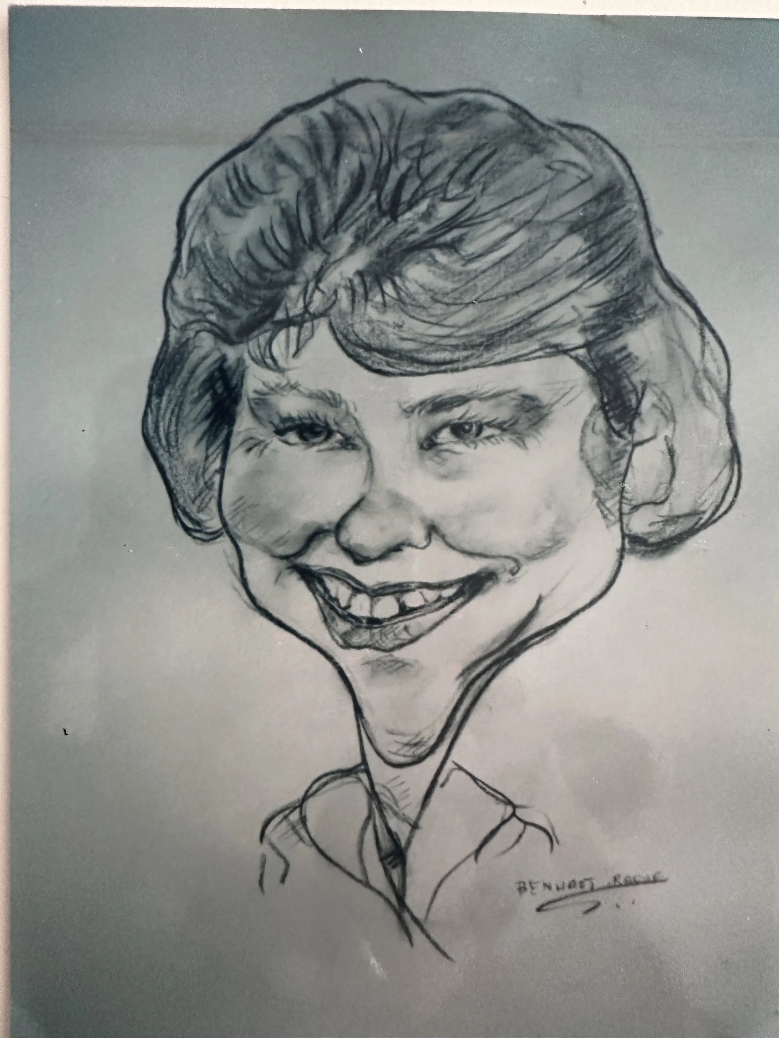 A black and white sketch of a woman with voluminous hair, smiling with teeth showing, wearing a shirt and tie. The artist's signature, 'BENHAT. KAIN,' is at the bottom right corner.