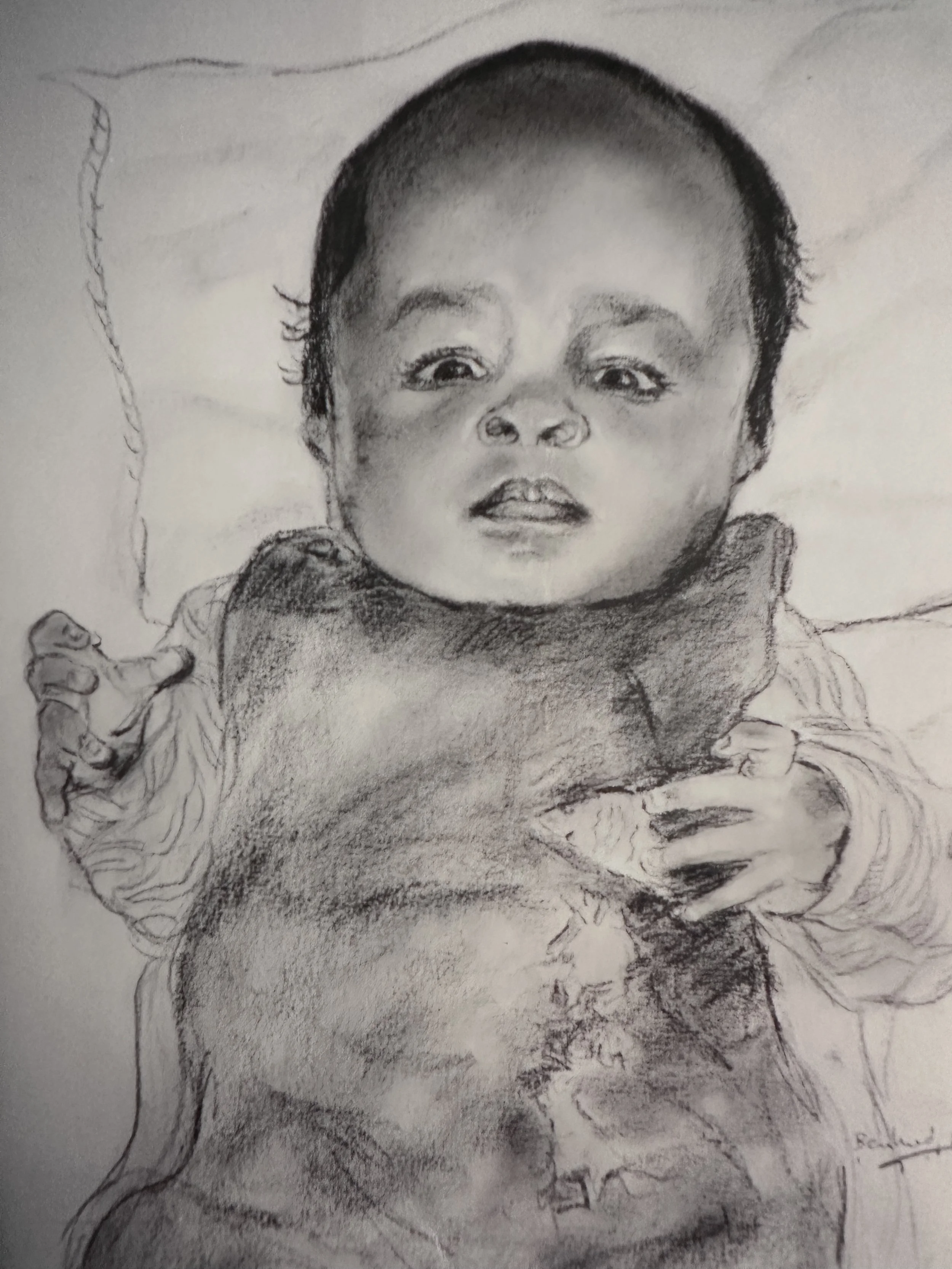 A detailed black and white pencil sketch of a baby with big eyes, short hair, and a slightly open mouth, wearing a jacket with a hood and holding what appears to be a blanket or cloth.