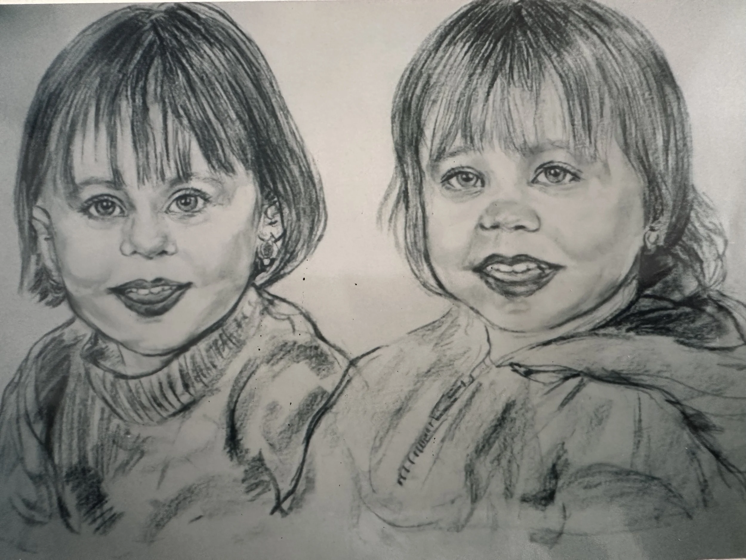 A pencil sketch of two young girls with shoulder-length hair, wearing patterned clothing, looking forward with neutral expression.
