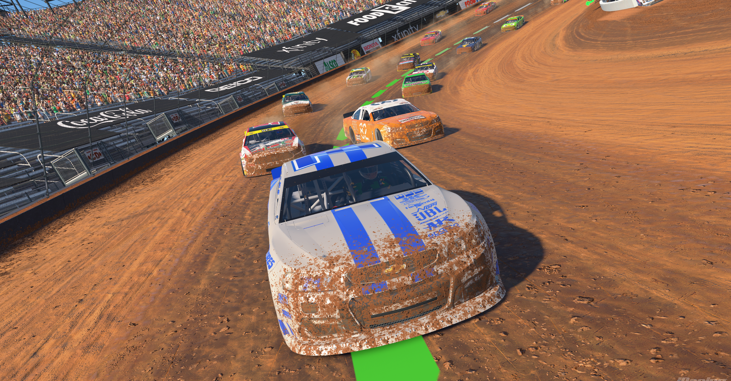 Race cars speeding on a dirt track with a packed crowd in the grandstands.