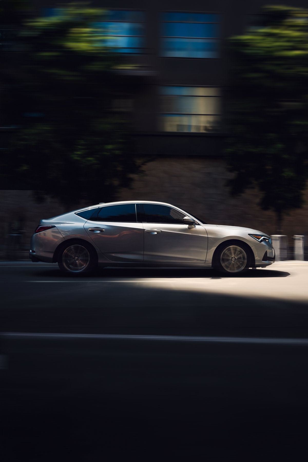 Acura Integra driving fast down a city street
