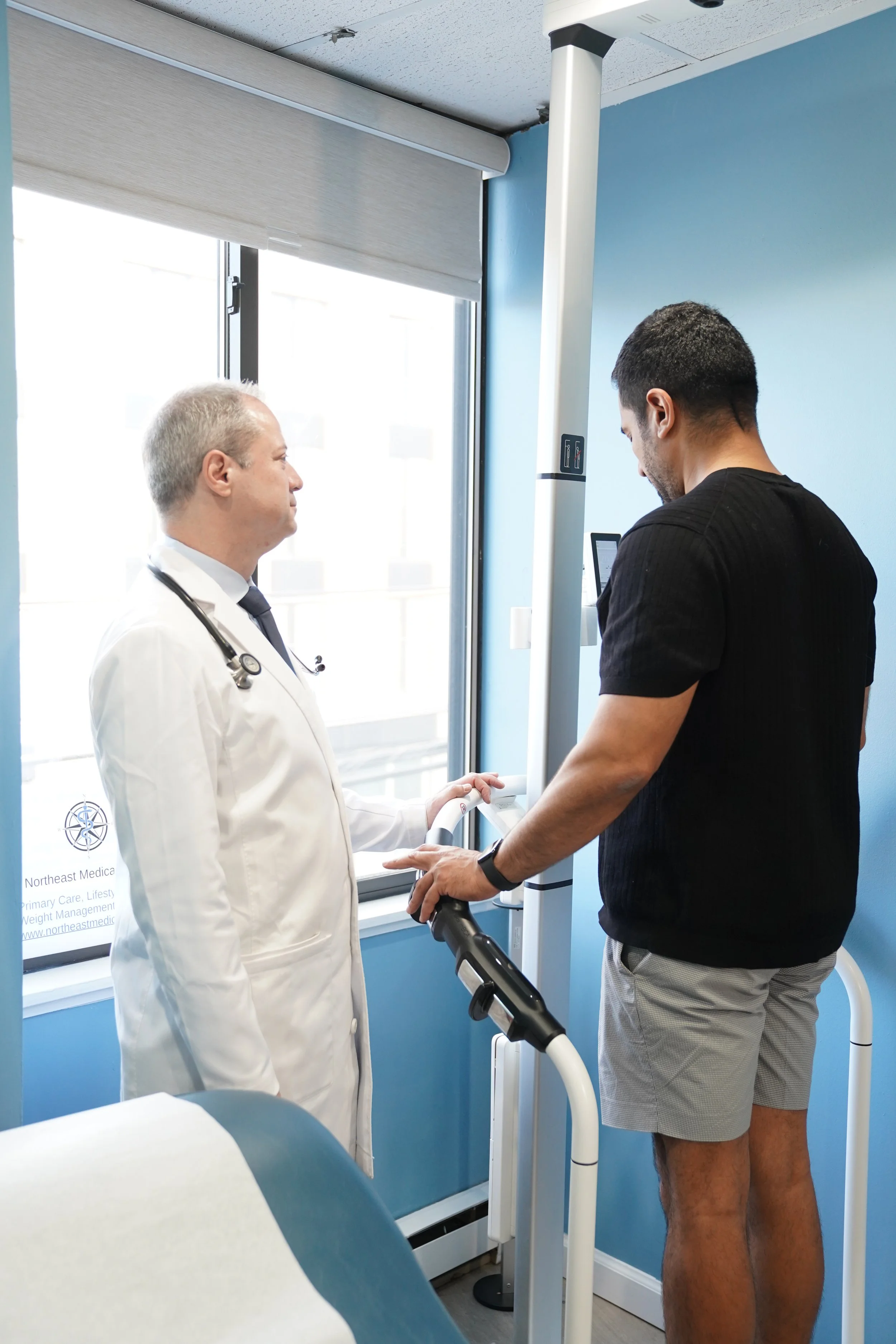 Dr. William Berger with a patient at Northeast Medical Practice using advanced bioimpedance technology to evaluate a patient key health markers.
