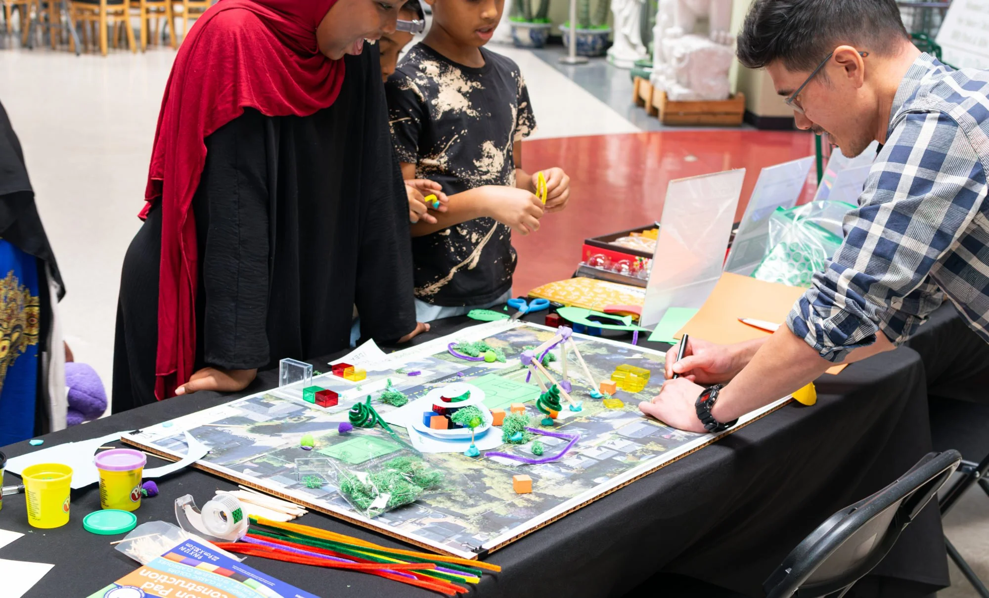 Travis collaborating with children who are excited about a park.