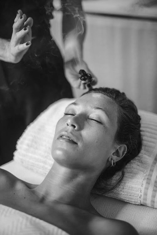 Black and white photograph of a woman reclining with her eyes closed.