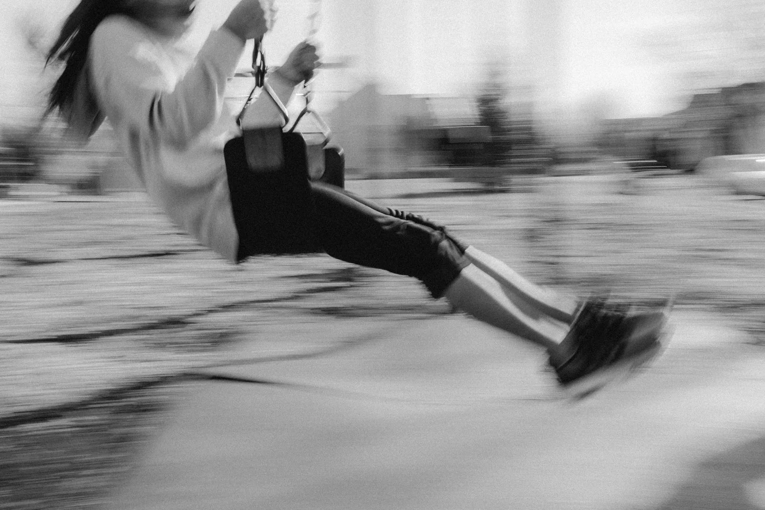 A child on a swing at the playground during daytime.
