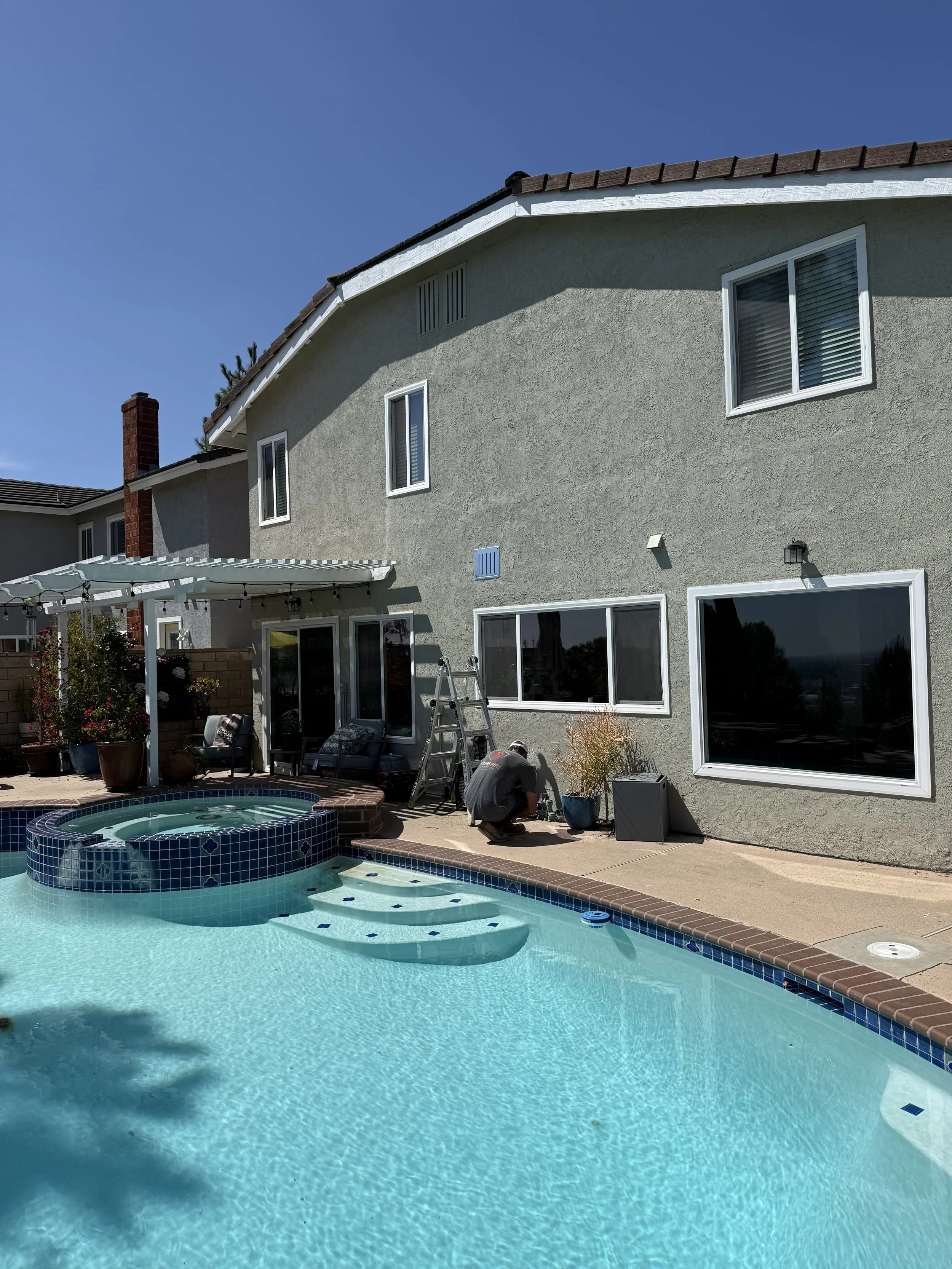 Image is of a home in Poway, CA that was retrofitted with BrandGuard's ember resistant gable vents on the side of the home near a pool and spa
