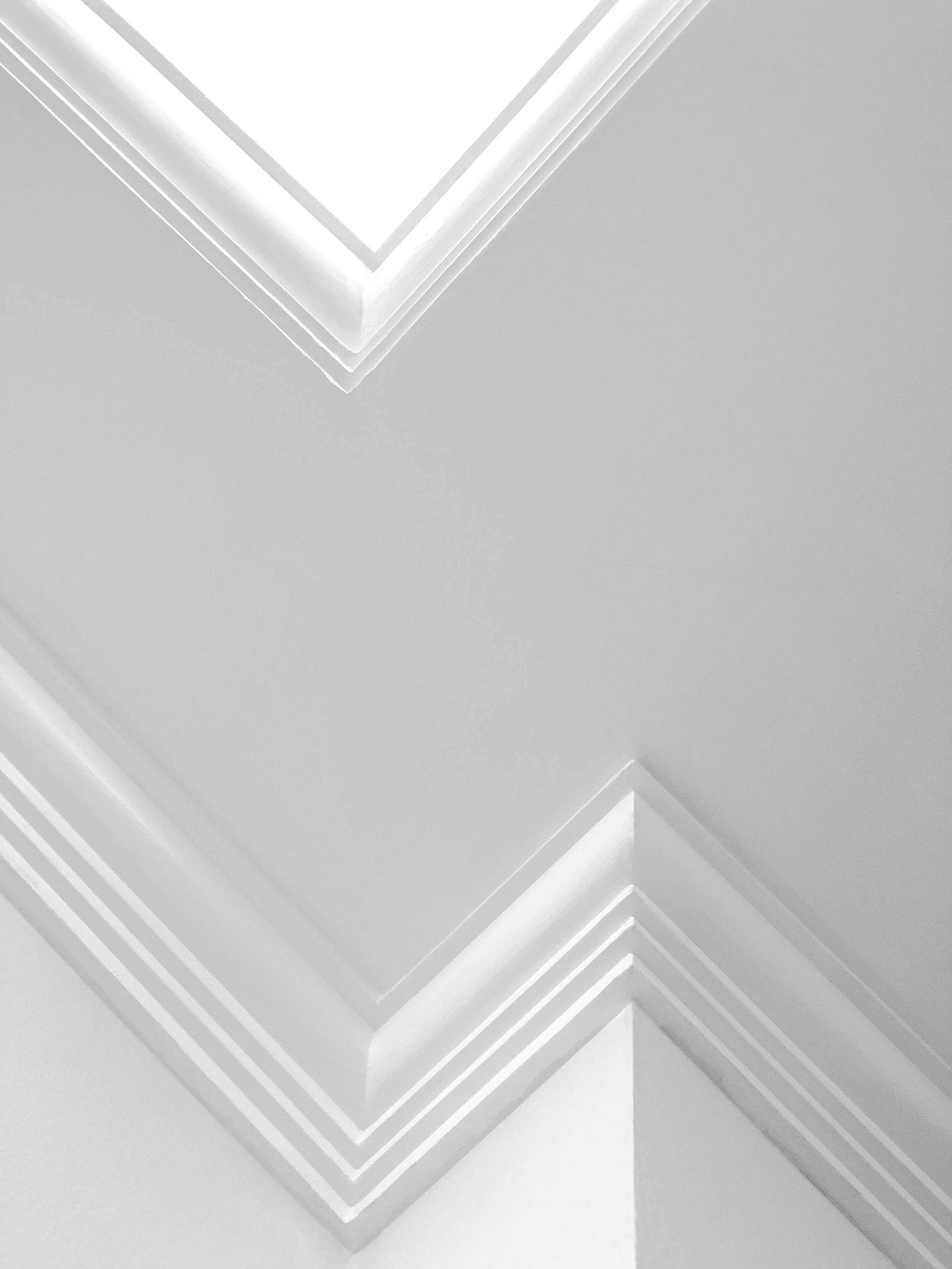 Detailed perspective shot focusing on the crisp, clean lines of ornate, multi-layered white crown molding in a luxury Clayton, MO home, illustrating expert architectural millwork painting.