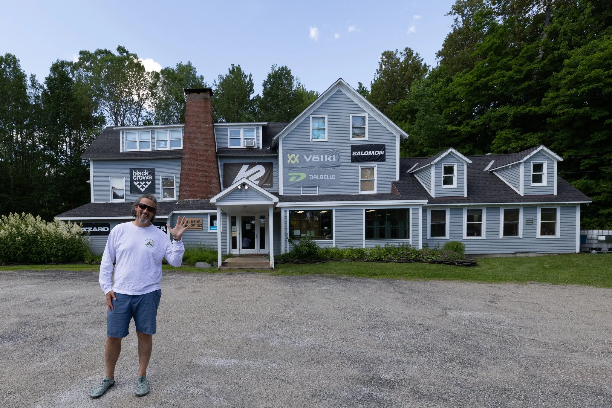 Derek Raynes waving hello outside Alpine Options ski shop in Warren, Vermont.