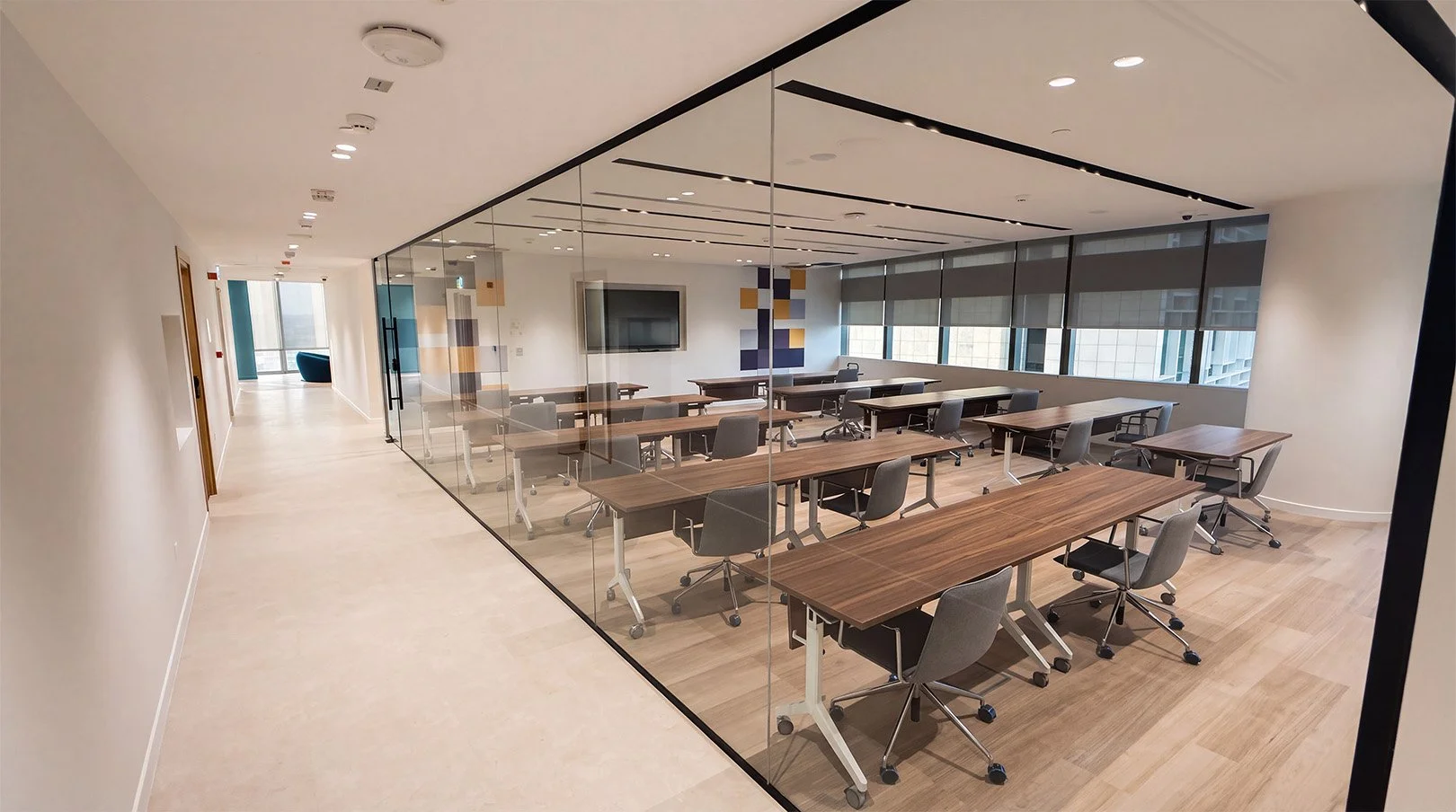 Glass-walled classroom with rows of tables and chairs at the KAFD campus.