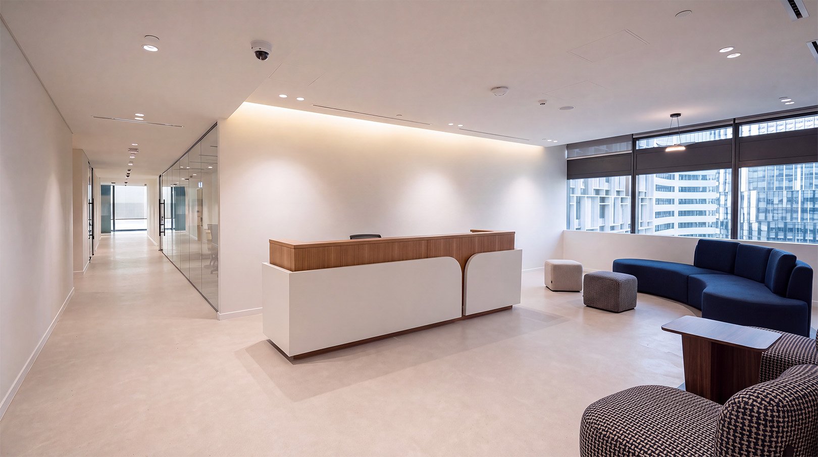 Campus reception area with a timber-fronted desk and blue lounge seating.