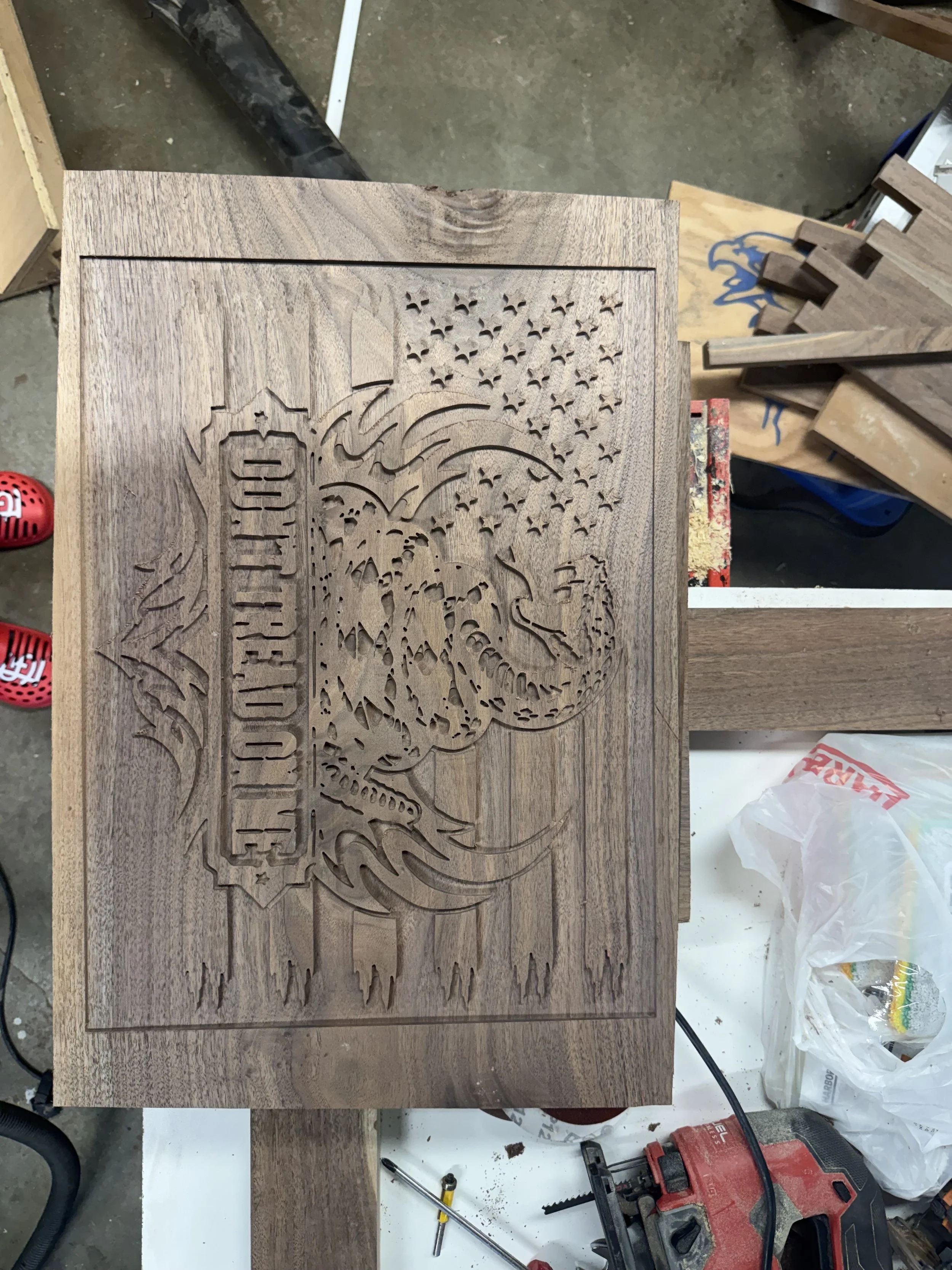 Wooden plaque with a laser-cut design including a pyramid, a drawing of a tree, a mountain, and stars, with an inscription at the bottom that appears to read 'Family'.