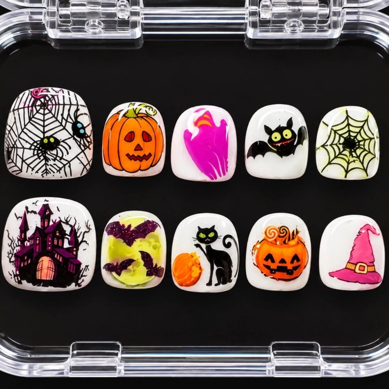 Spooky Season kids' press-on set: ten short nails with spiderwebs, jack-o'-lanterns, a ghost, a bat, a haunted house, a black cat and a witch hat, in a clear case.