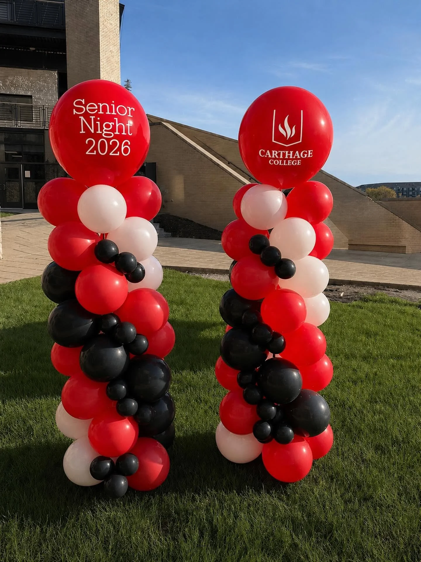 Red, white, and black balloon columns outside Carthage College, featuring “Senior Night 2026” and the college logo.