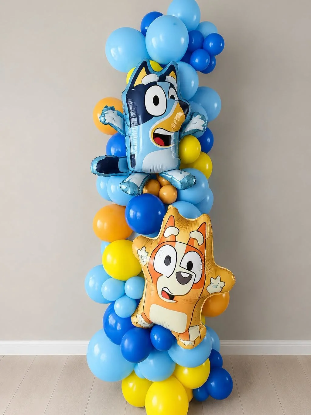 Colorful blue, yellow, and orange balloon column with two cartoon animal foil balloons