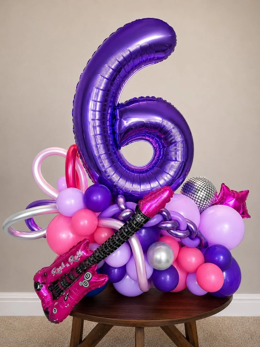 Purple number six balloon bouquet with colorful balloons, disco ball, star balloon, and pink guitar balloon decoration.