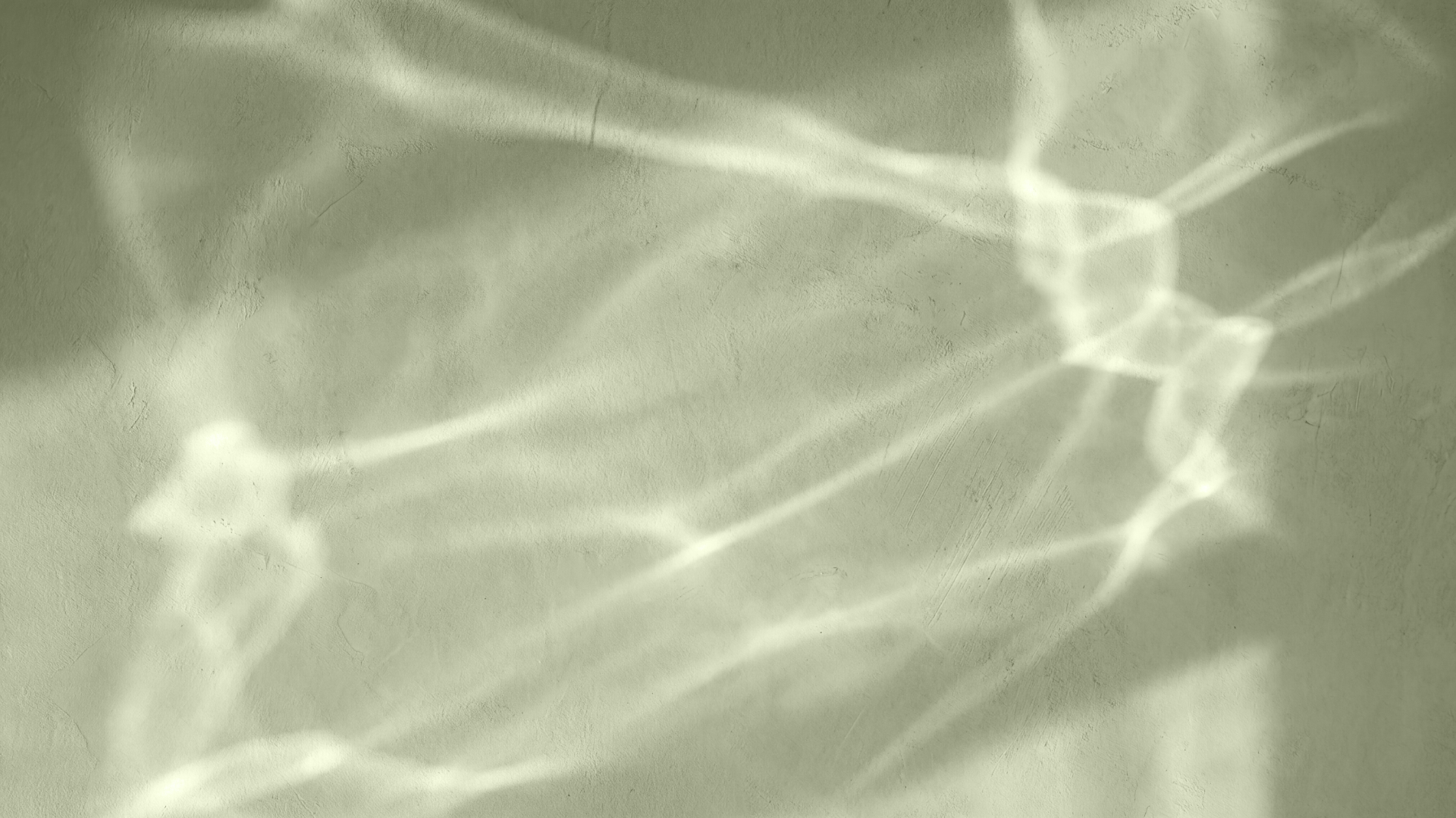 Light reflections on a textured wall creating abstract patterns.
