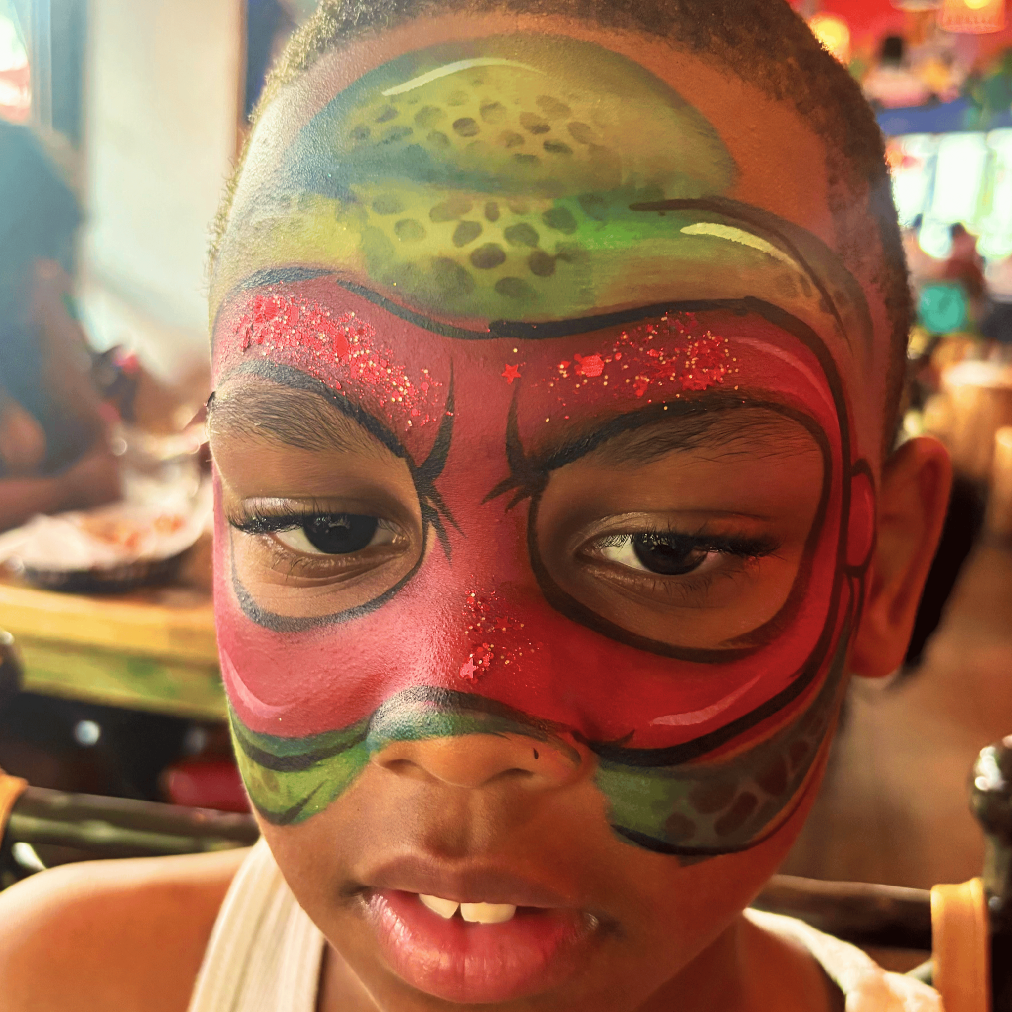 Close-up of a person's face with painted at teenage mutant ninja turtles