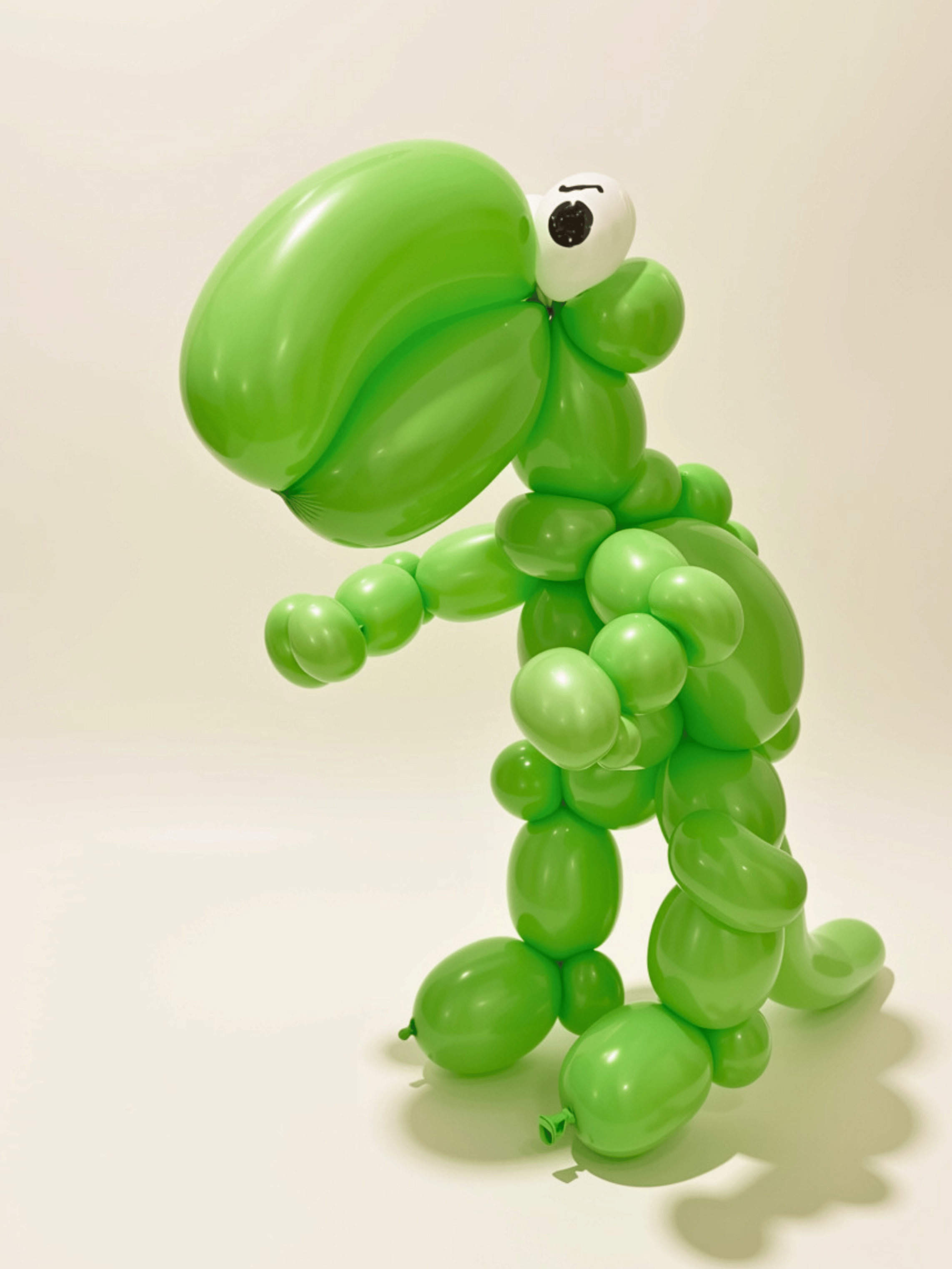 Balloon sculpture of Yoshi, a green dinosaur character from Mario, with drawn eyes, on a plain white background.