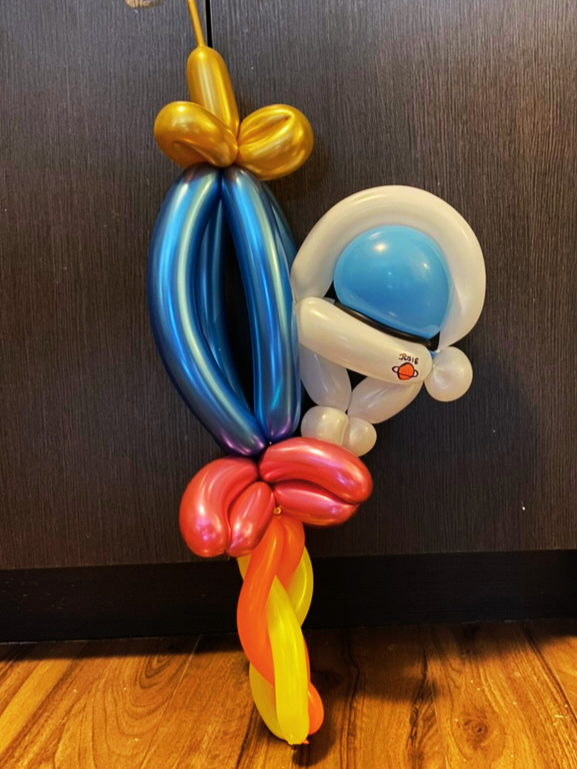 Colorful balloon sculpture of a rocket with an astronaut attached