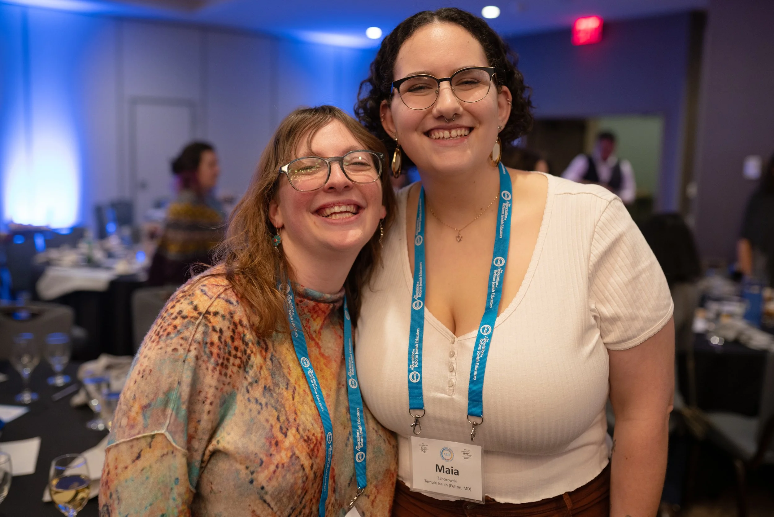 Two attendees wearing conference lanyards pose together at the ARJE conference in Minneapolis